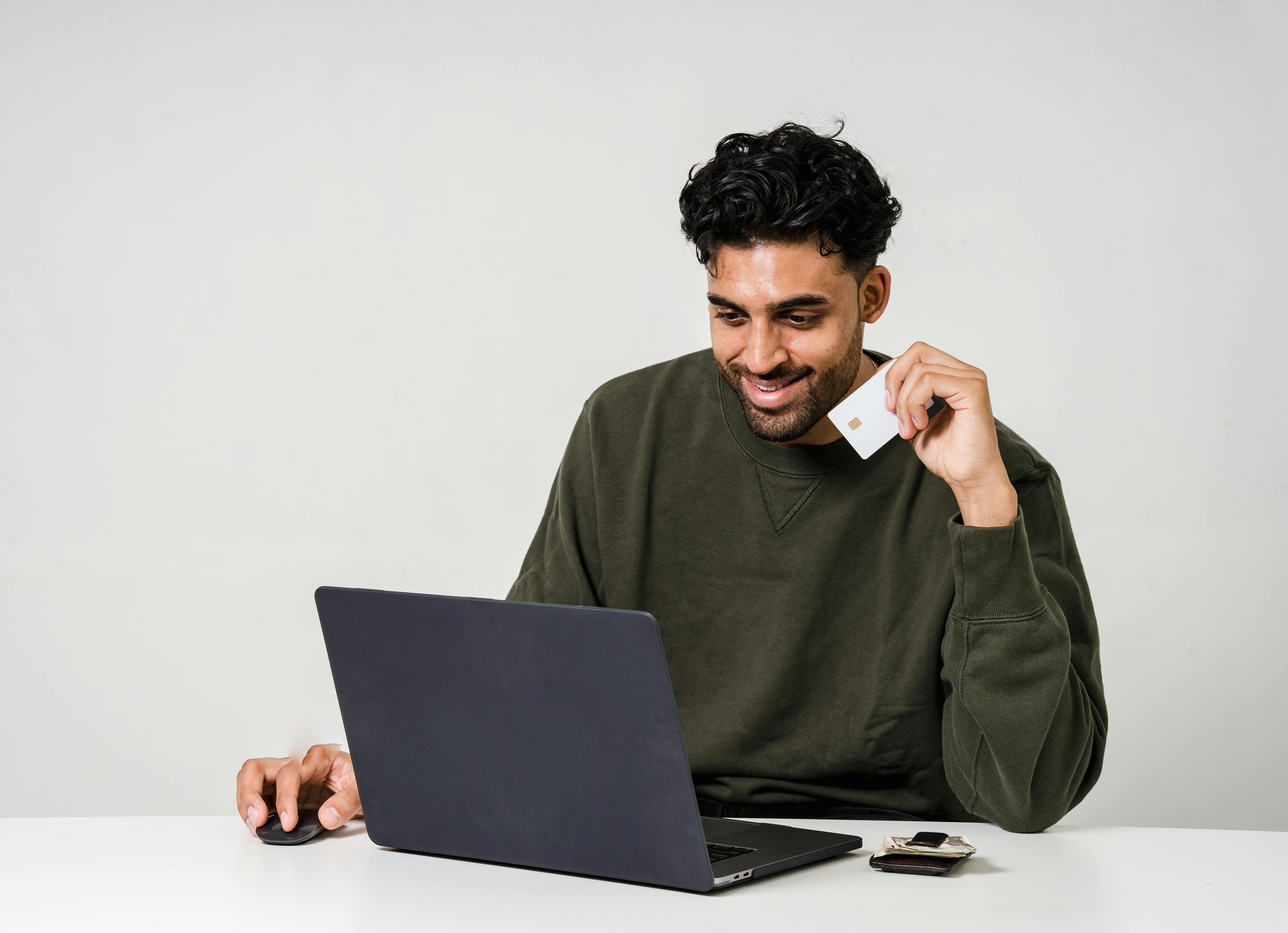 Man working on a laptop at a wooden table.