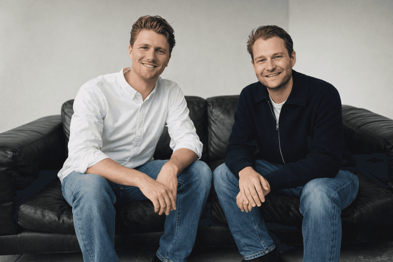 A group of four people engaged in a discussion while seated in a cozy, plant-filled setting.