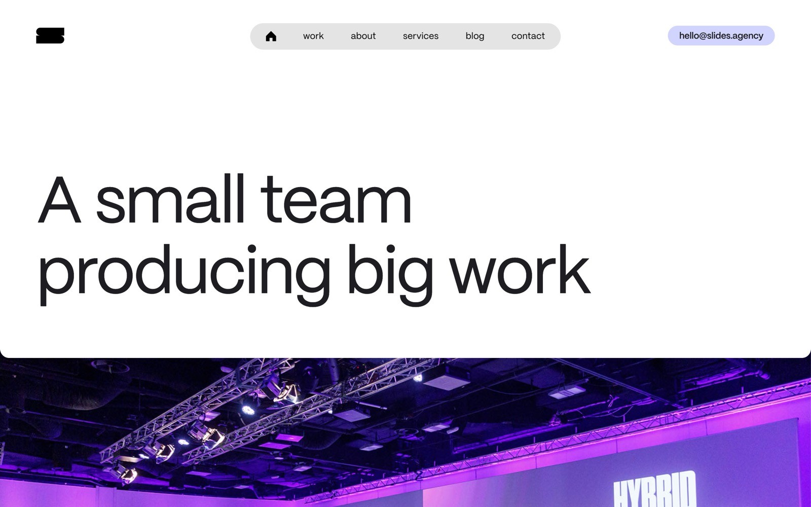 Website screenshot displaying the prominent headline "A small team producing big work" over a purple-lit stage.