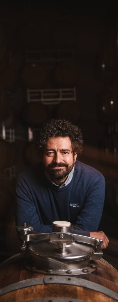 Black and white portrait of a smiling person with curly hair