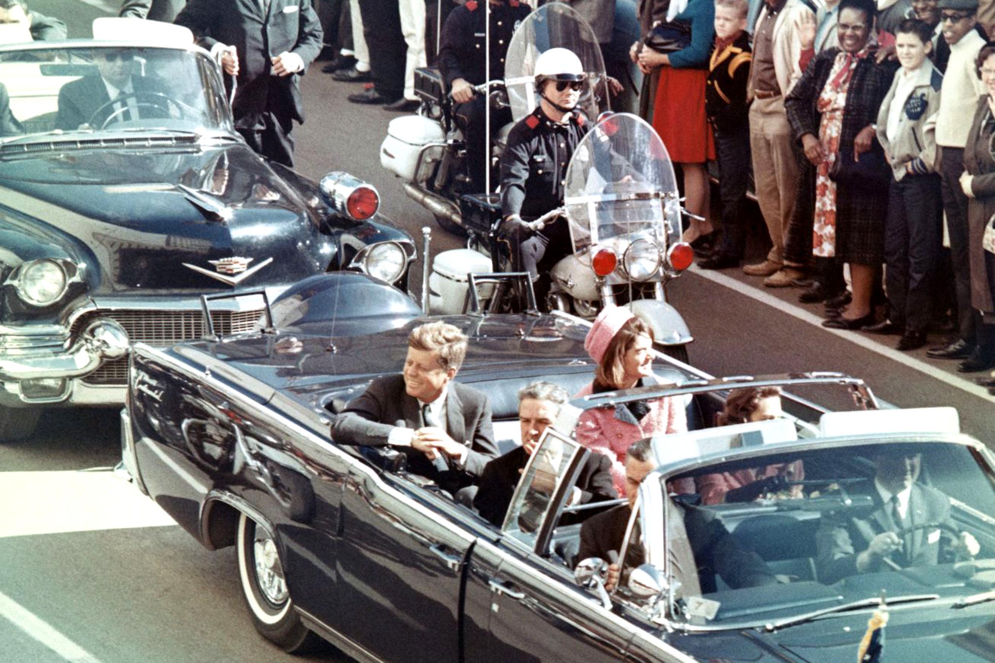 President John F. Kennedy and Jackie Kennedy riding in the open top presidential motorcade through Dallas, Texas on November 22, 1963.