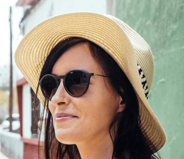 a young man wearing glasses standing in front of a mountain