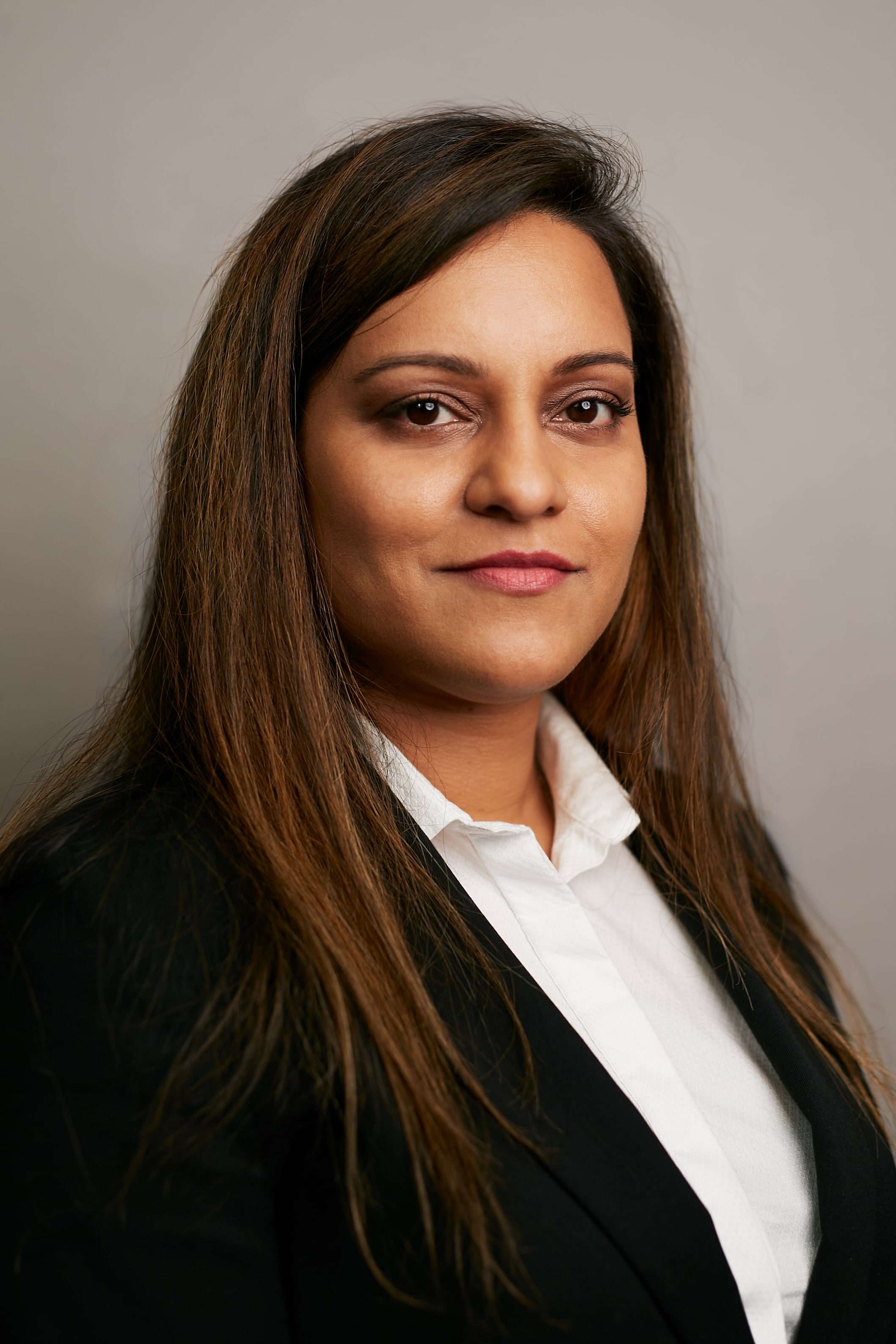 Woman in a black jacket and white shirt.