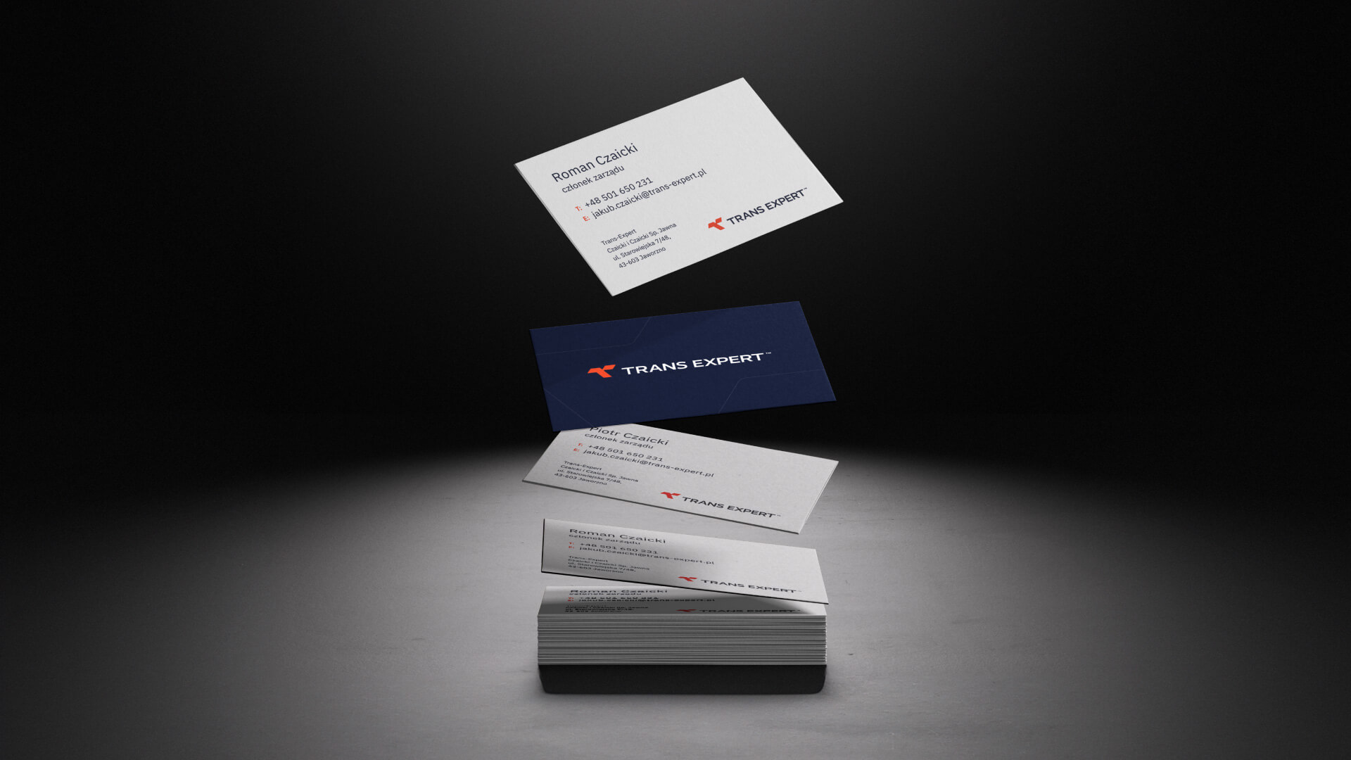 Several floating and stacked Trans Expert business cards in white and dark navy blue. The cards display the company logo and contact information.