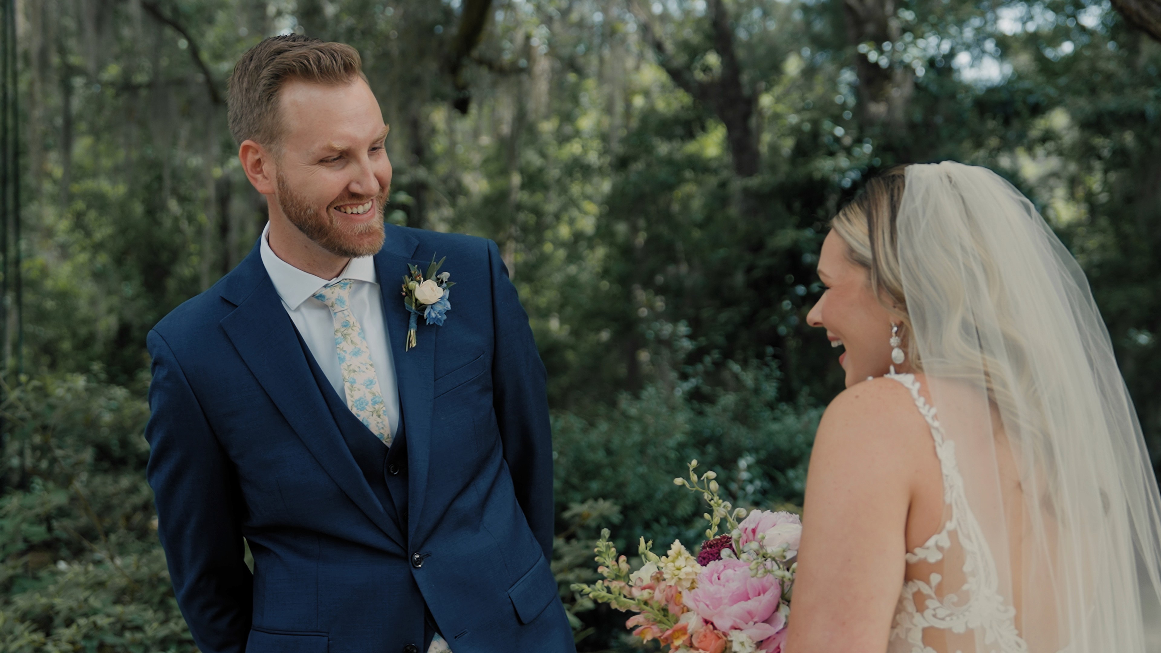 Colin and Alyssa smiling at one another during their first look