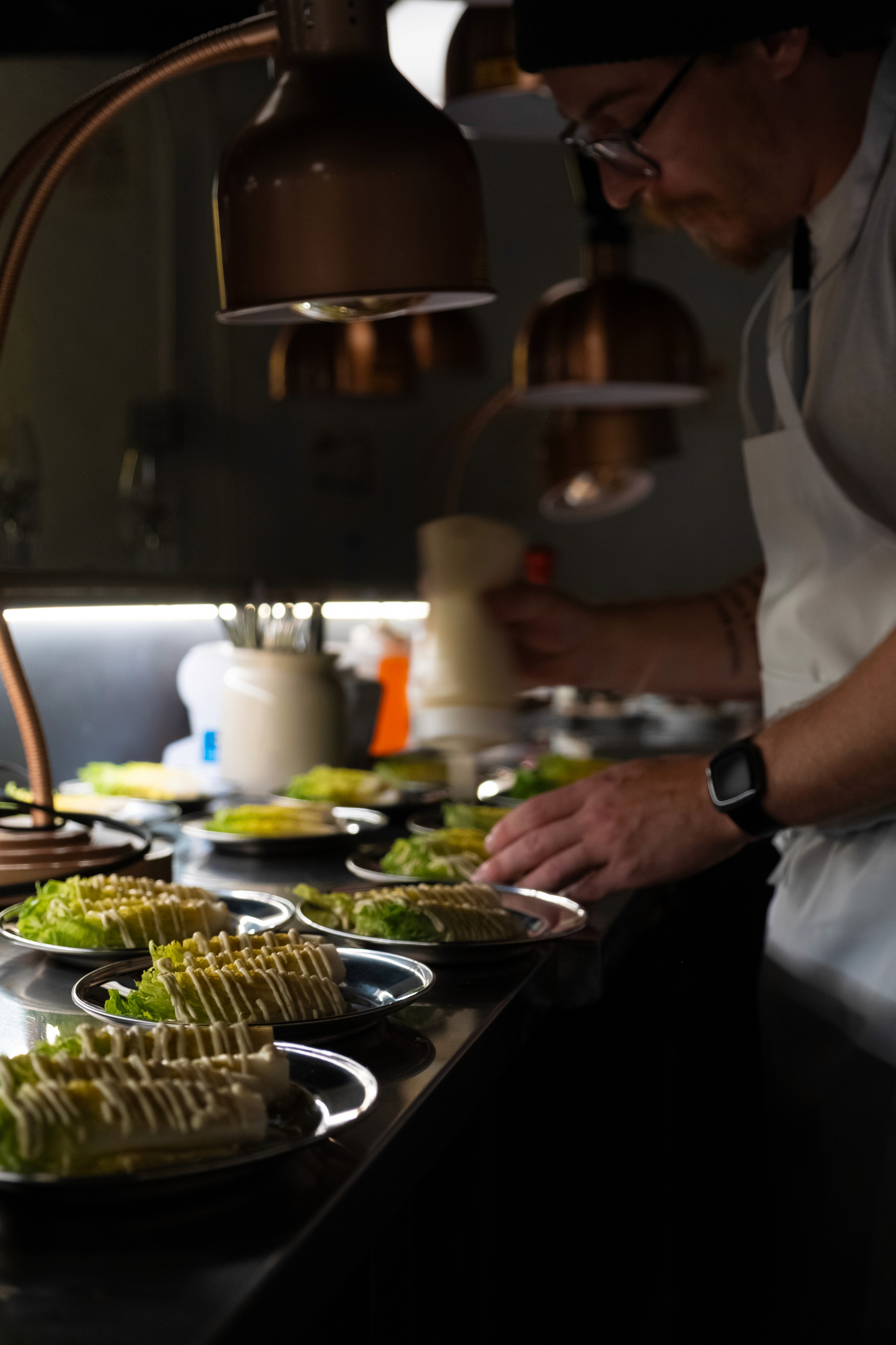 Un cuisinier prépare les entrées de salades césar.