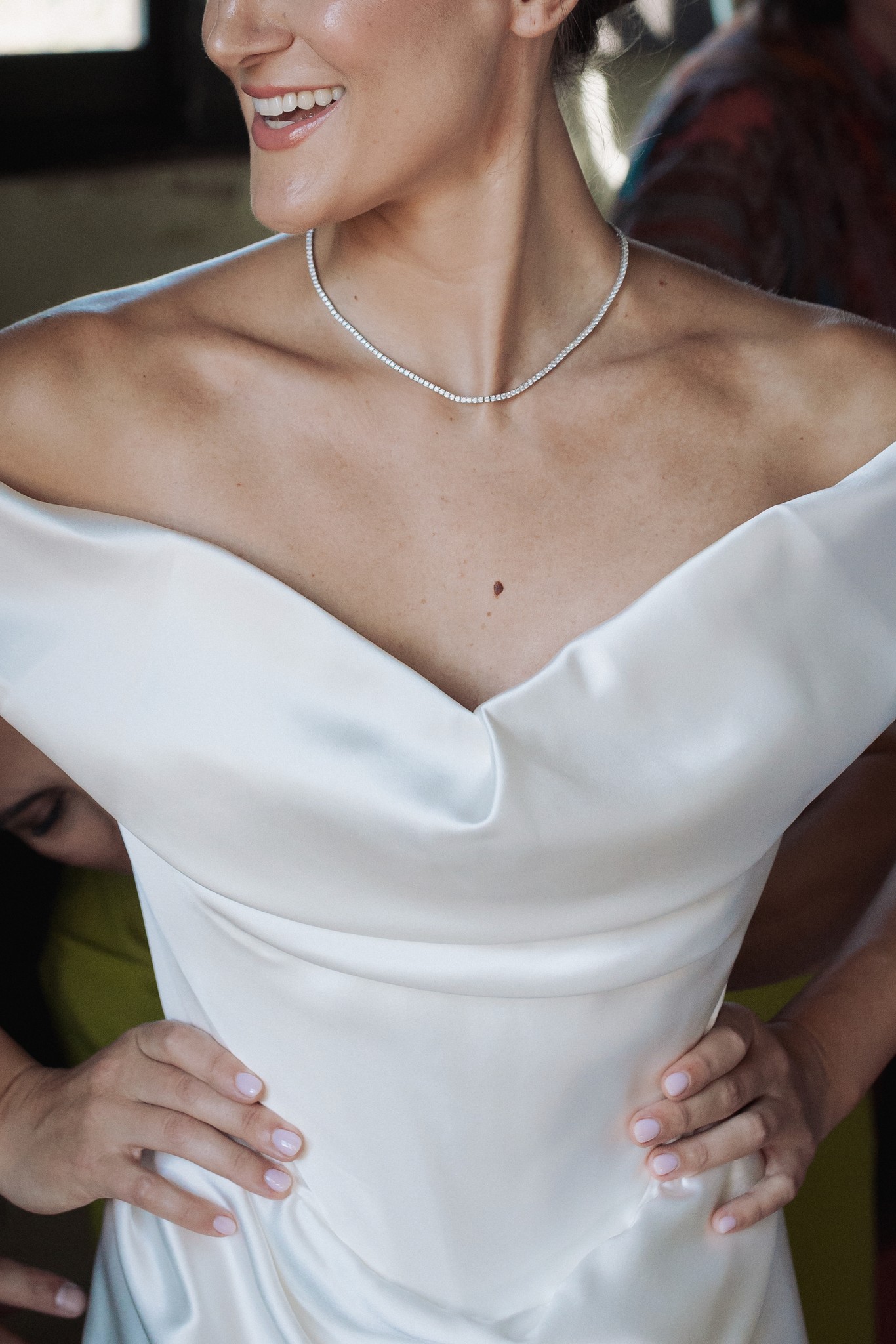 Sposa con abito bianco e collana di perle sorride ai preparativi del matrimonio al Castello di Scipione