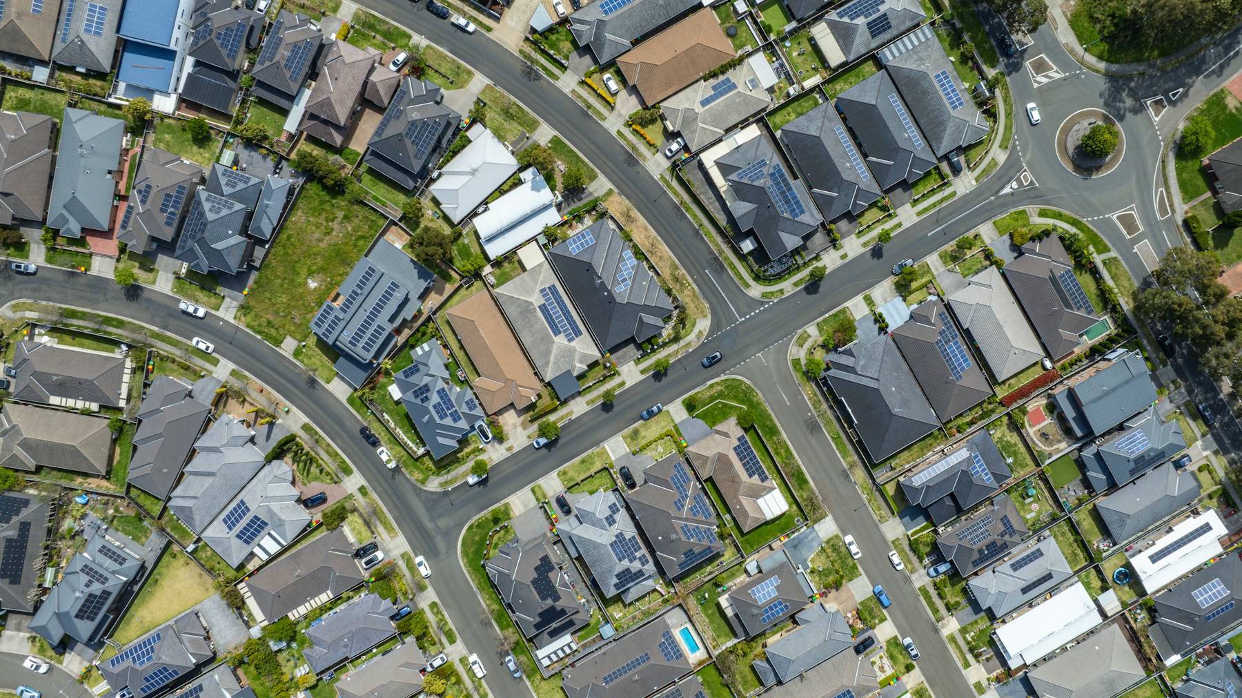 Aerial view of suburban houses with solar panels.