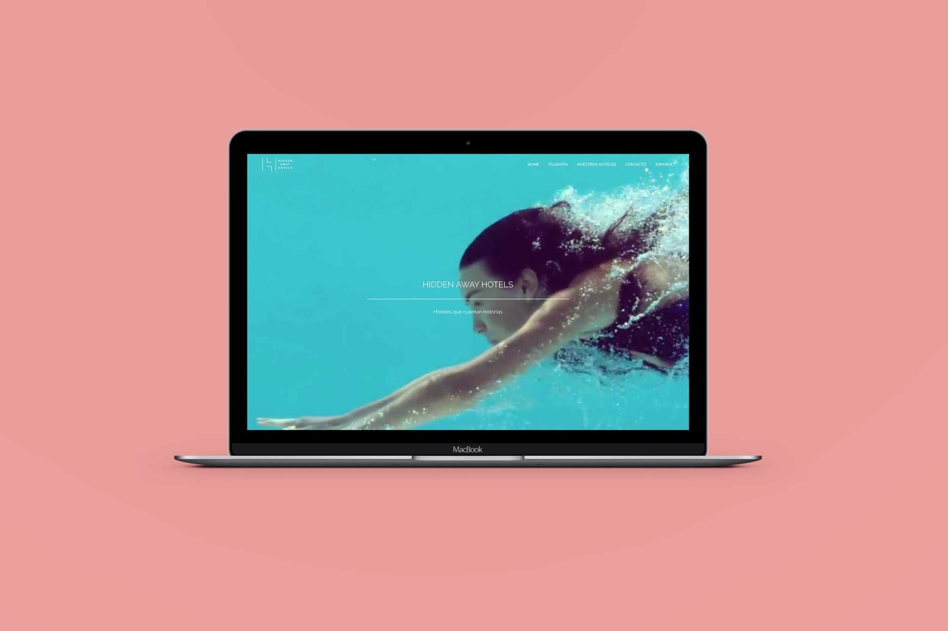 Computadora portátil MacBook con fondo rosa mostrando a una nadadora bajo el agua.