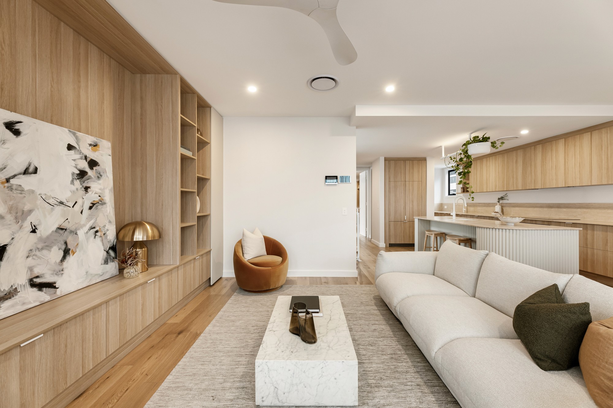 Living area featuring a custom timber entertainment wall and neutral furnishings.