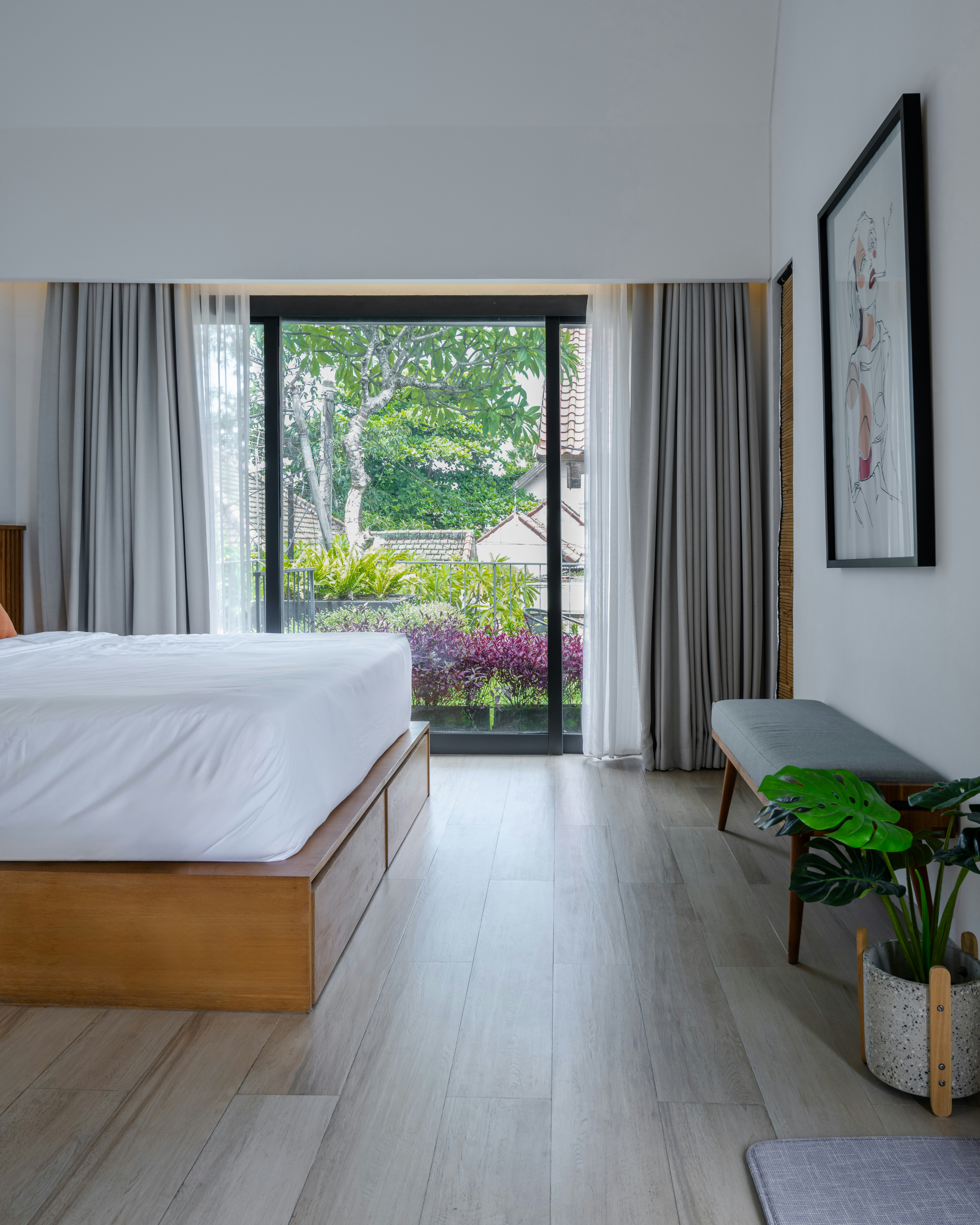 Bedroom with a large window and comfortable seating.