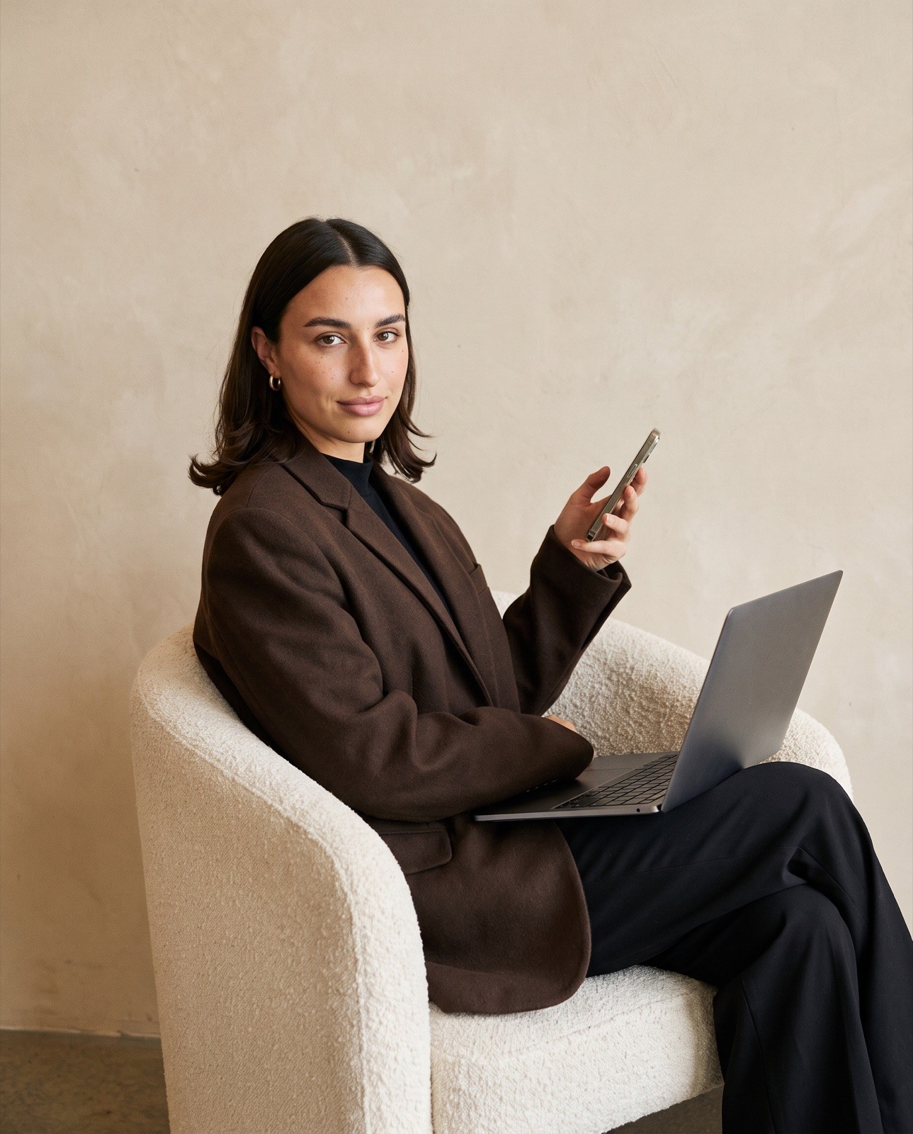 Margaux Ellis, co-founder and PR director of SEEN, seated in the studio with a laptop on her knees.