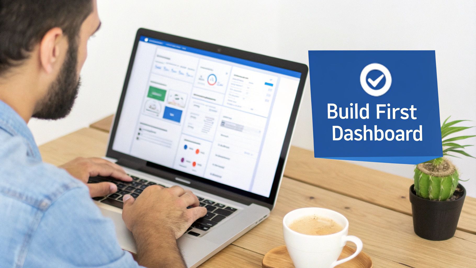 A man works on a laptop displaying data visualization dashboards, with a coffee cup and plant.