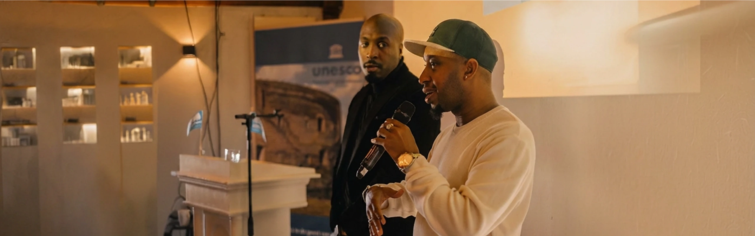 Randy Telg speaking at a professional event alongside a colleague