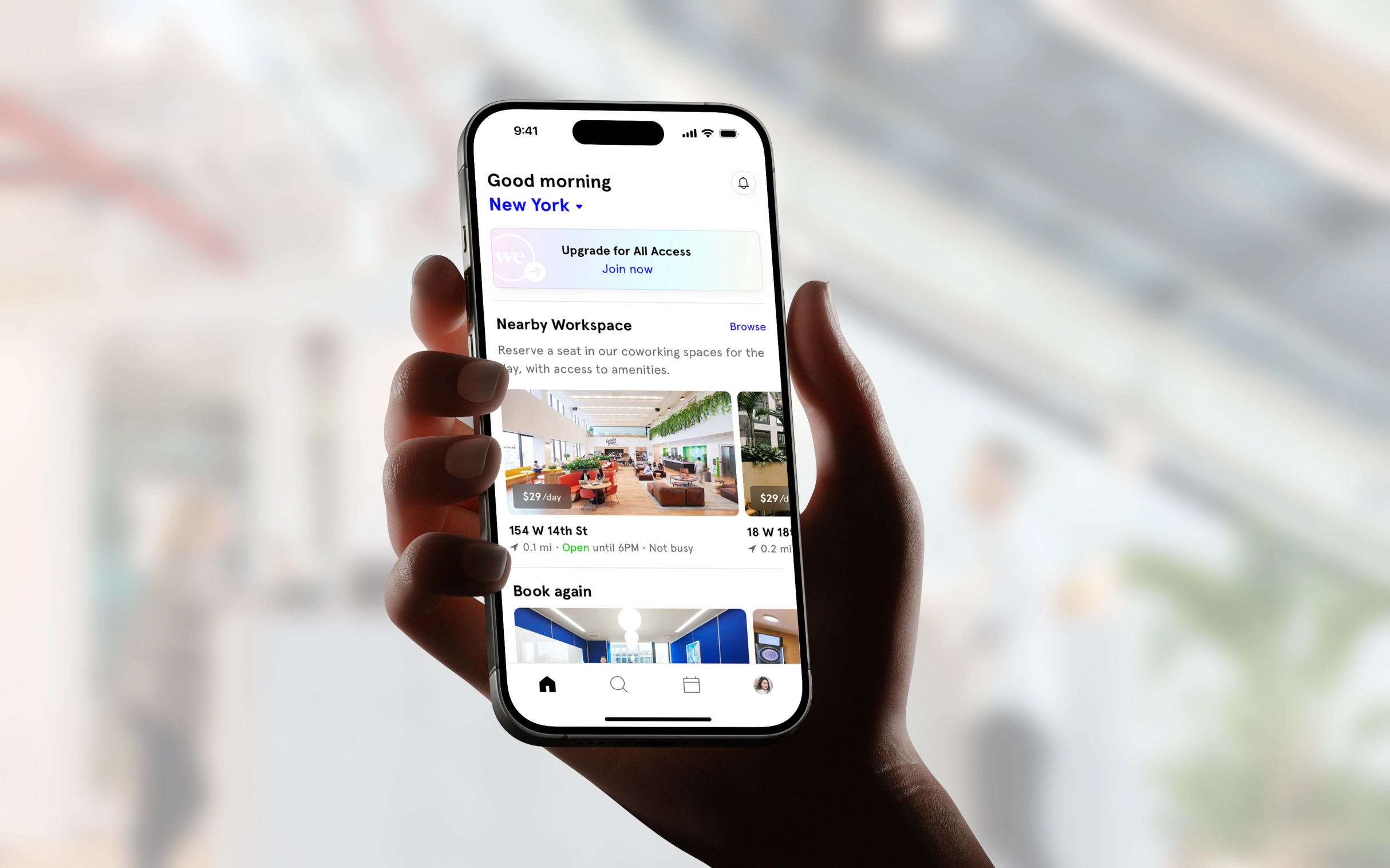 Modern home office setup with a monitor, ergonomic chair, keyboard, and indoor plants near a window with blinds.