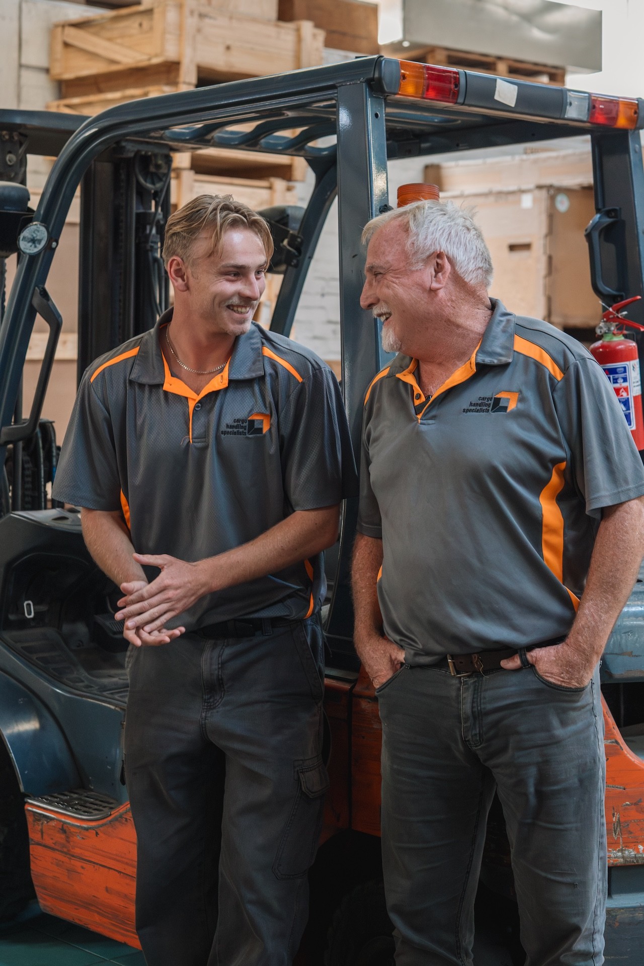 Logistics supervisor in safety gear overseeing crane operations at a shipping port.
