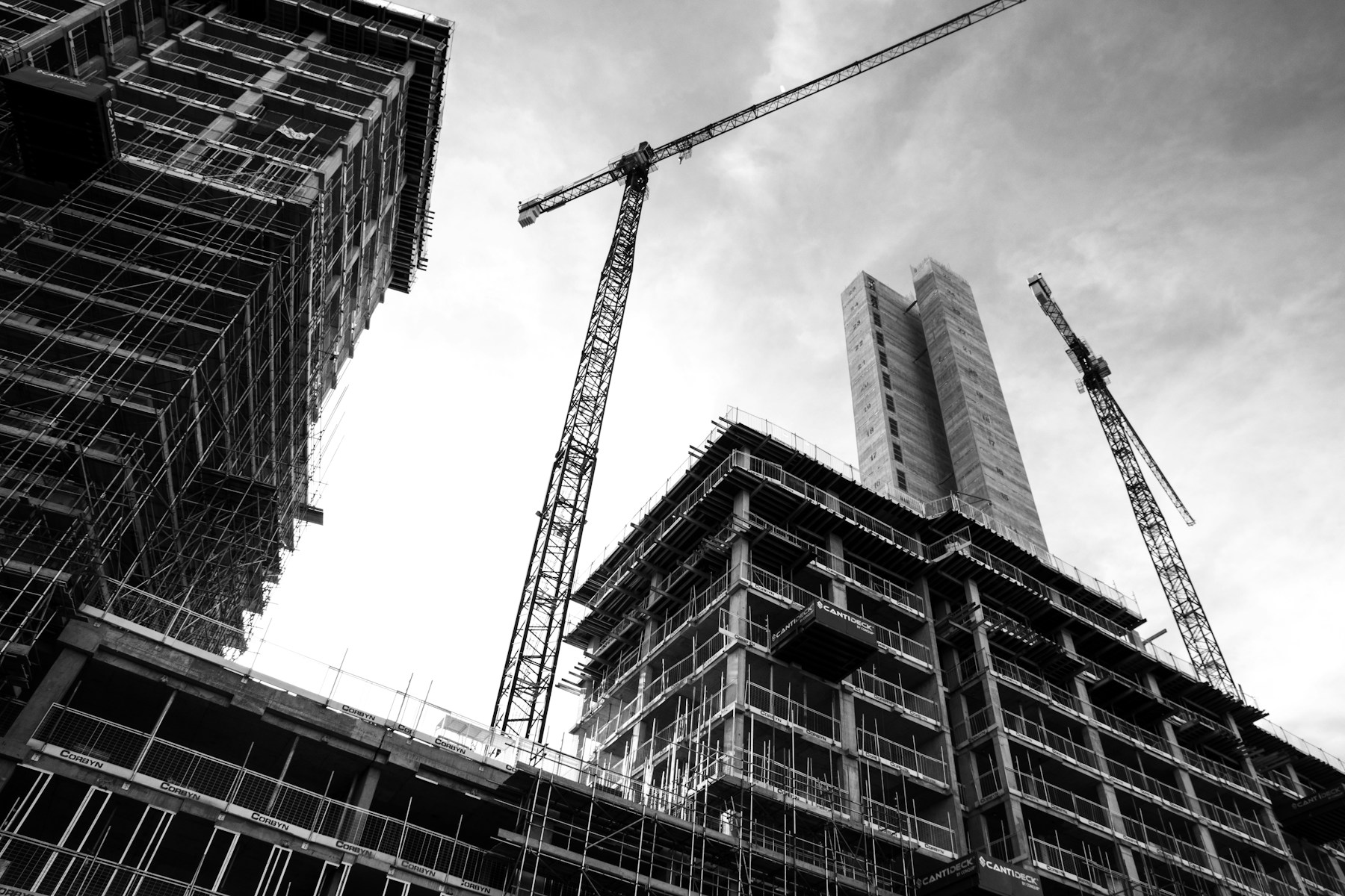 Construction site with multiple cranes and unfinished buildings.