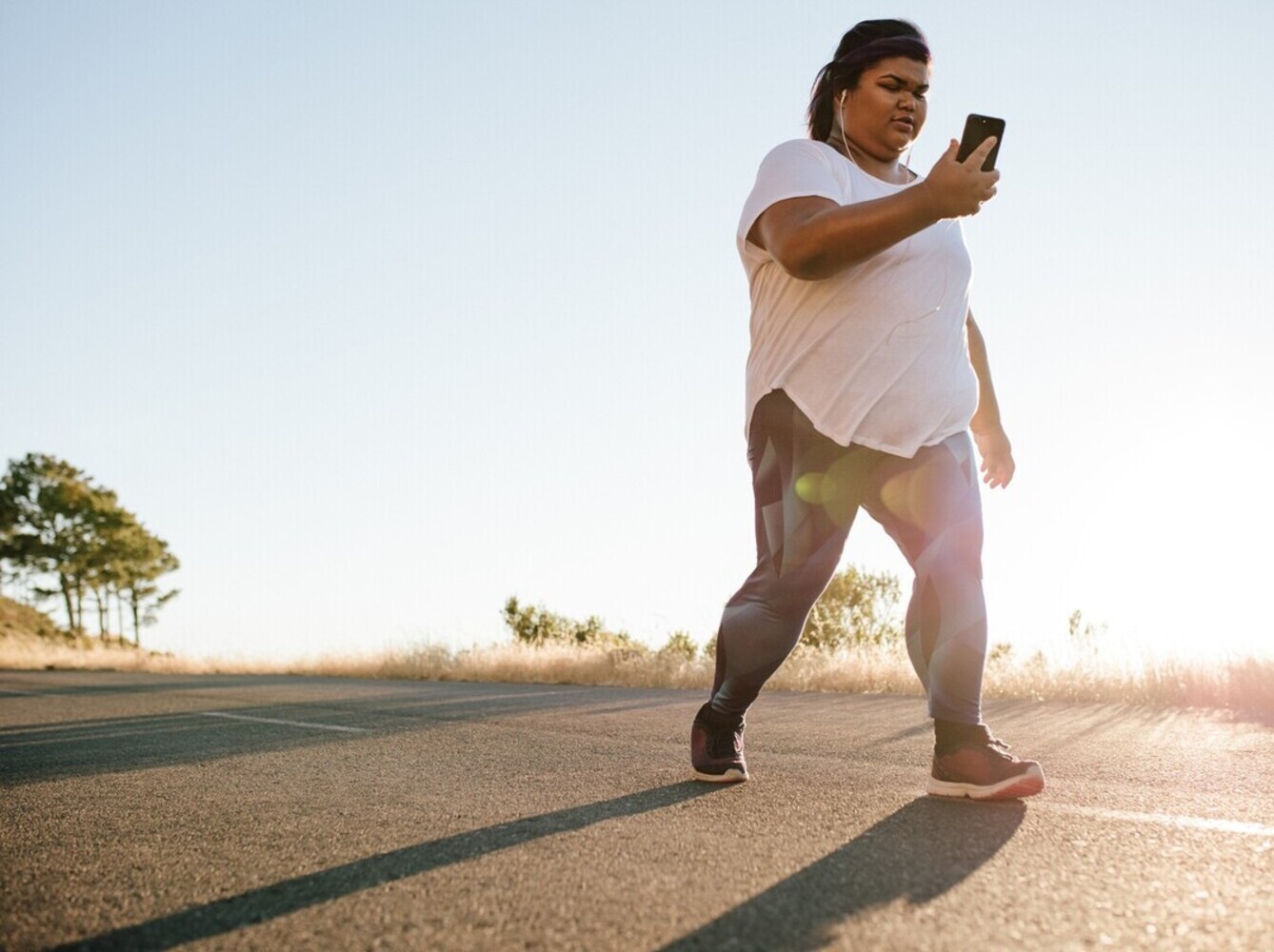 overweight woman going for a walk outside in the morning to support her weight loss yoga routine