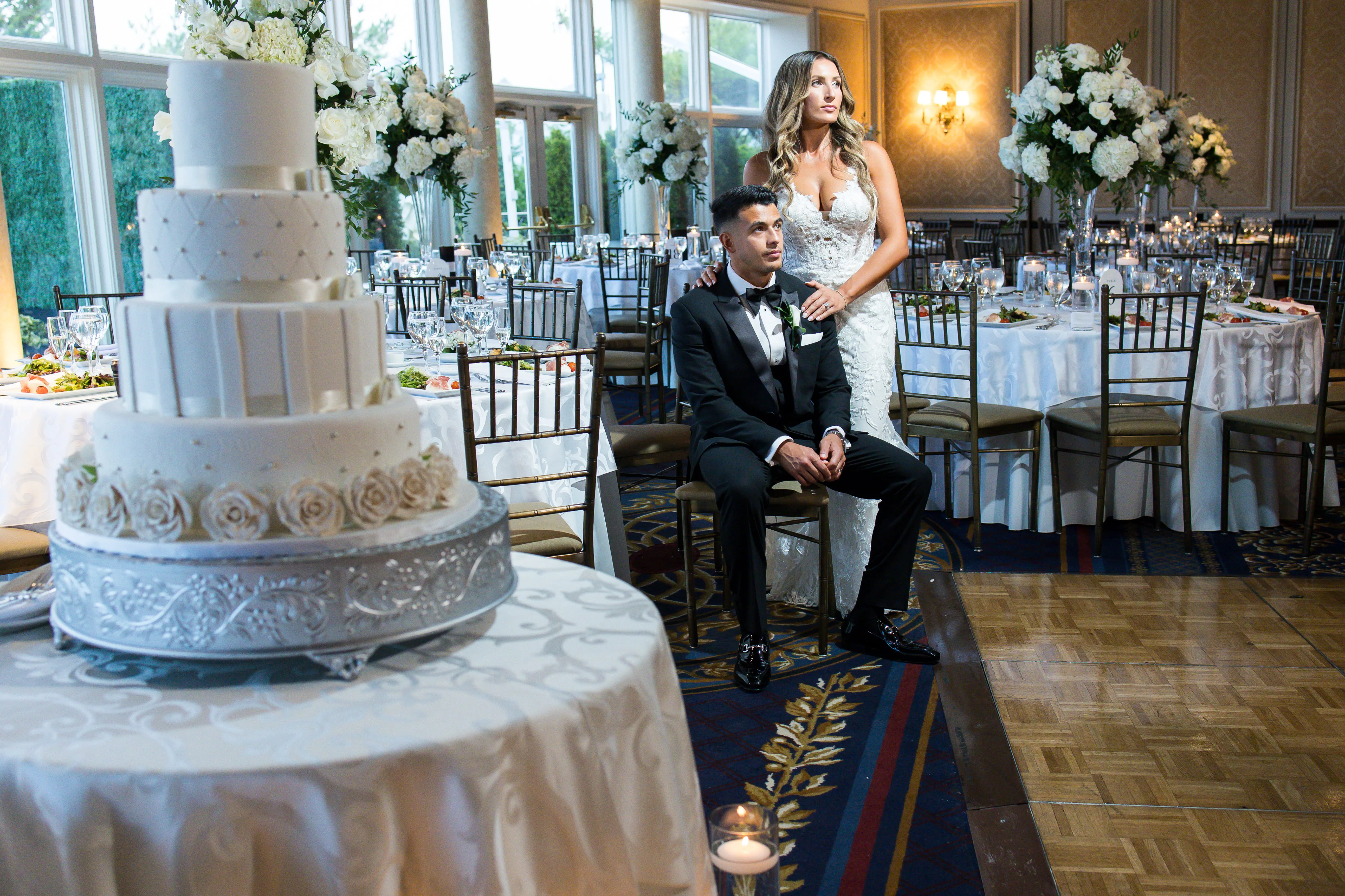 Elegant wedding couple posing at VIP Country Club reception with cake and décor