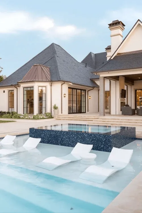 Custom negative edge spa with dark mosaic tile and resort pool for Preston Hollow Dallas estate by Blount Designs