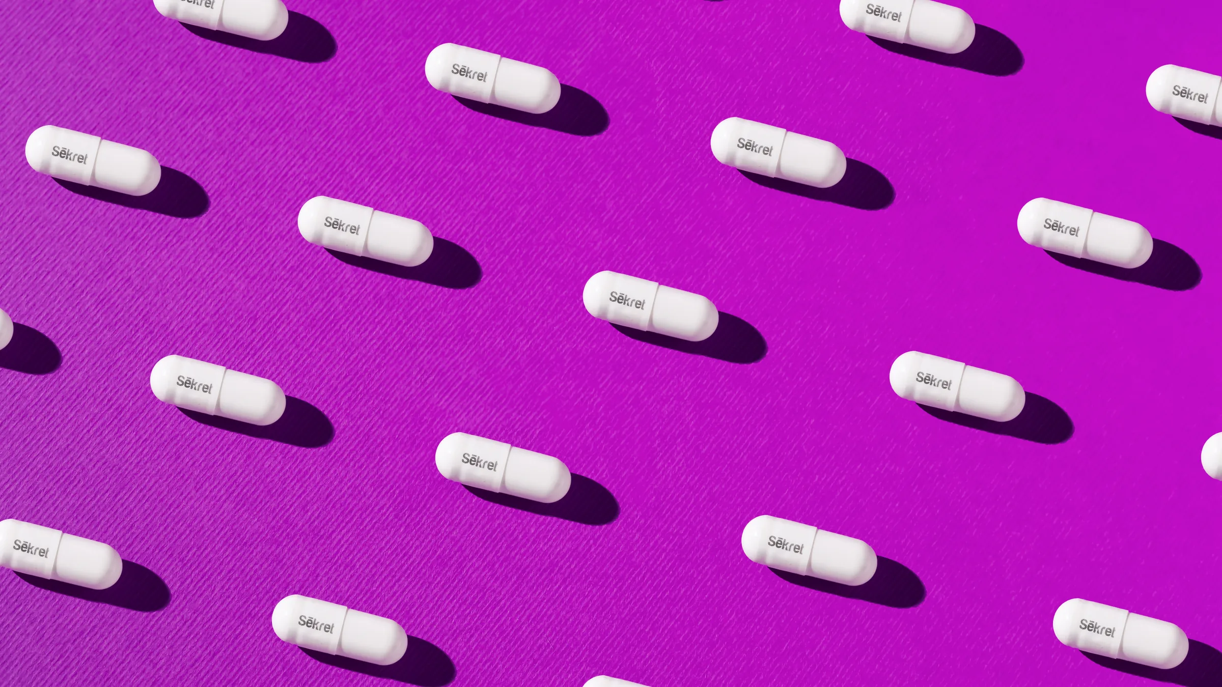 Rows of white Sēkret capsules on a purple background