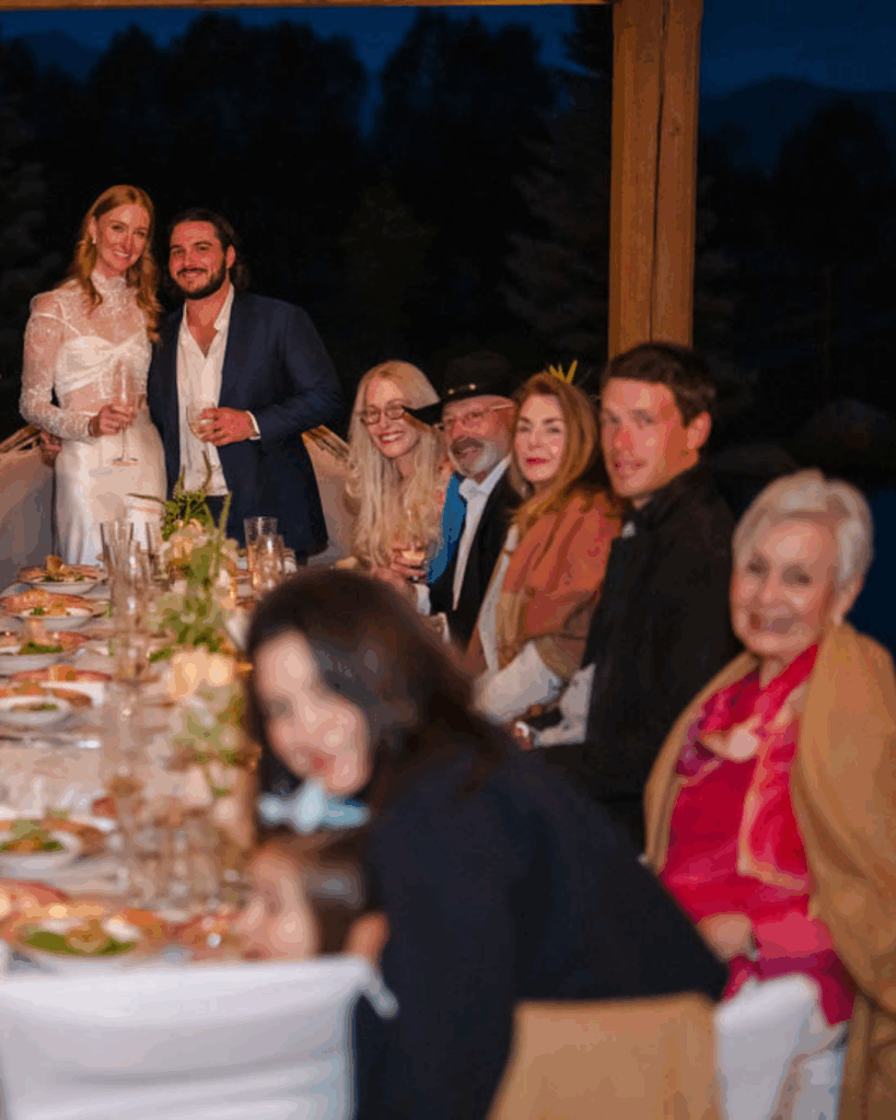 Newlyweds standing at a dinner table during a speech