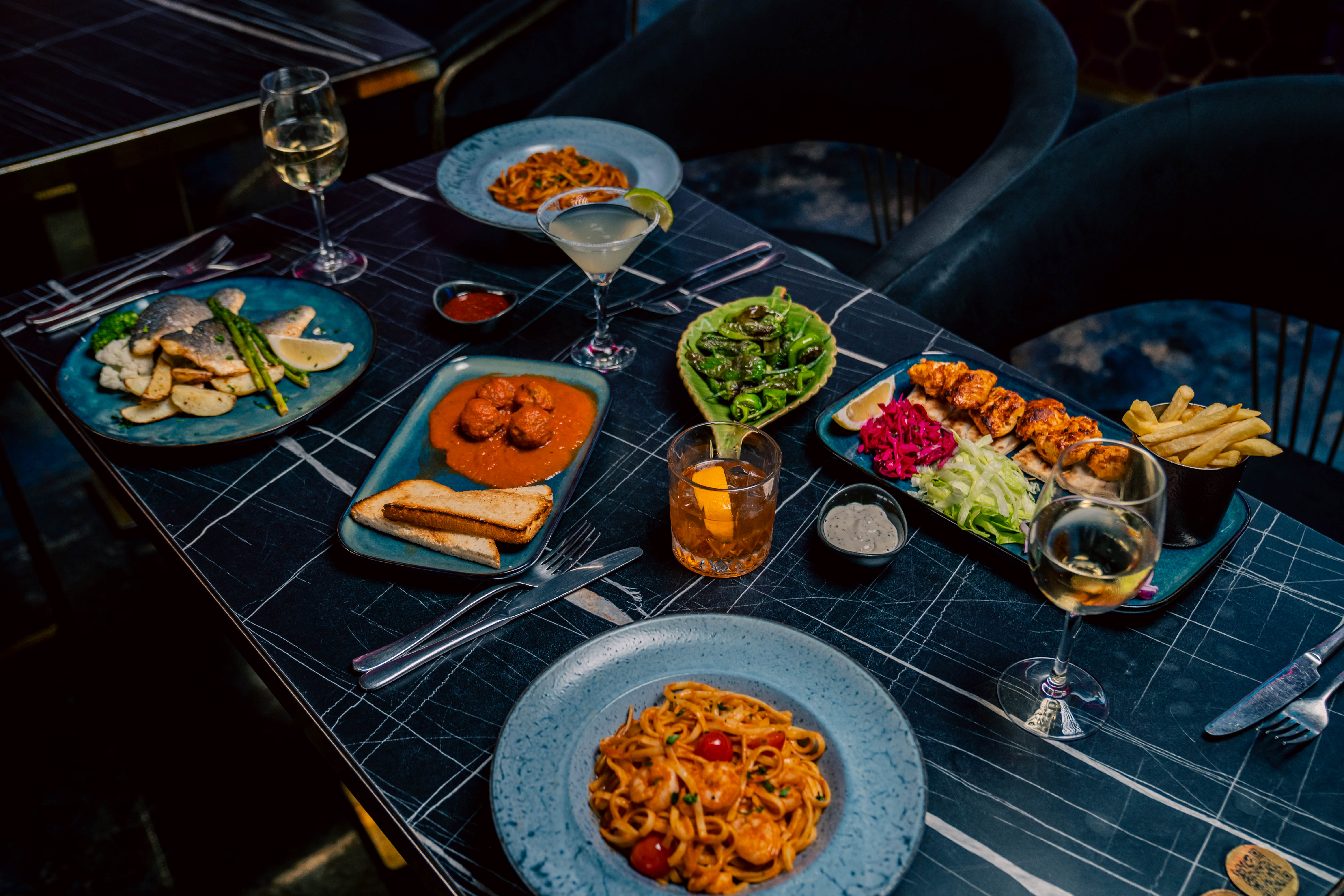 Fresh Mediterranean cuisine featuring pasta, seabass, prawns, and sides at Billionz Lounge, Nottingham