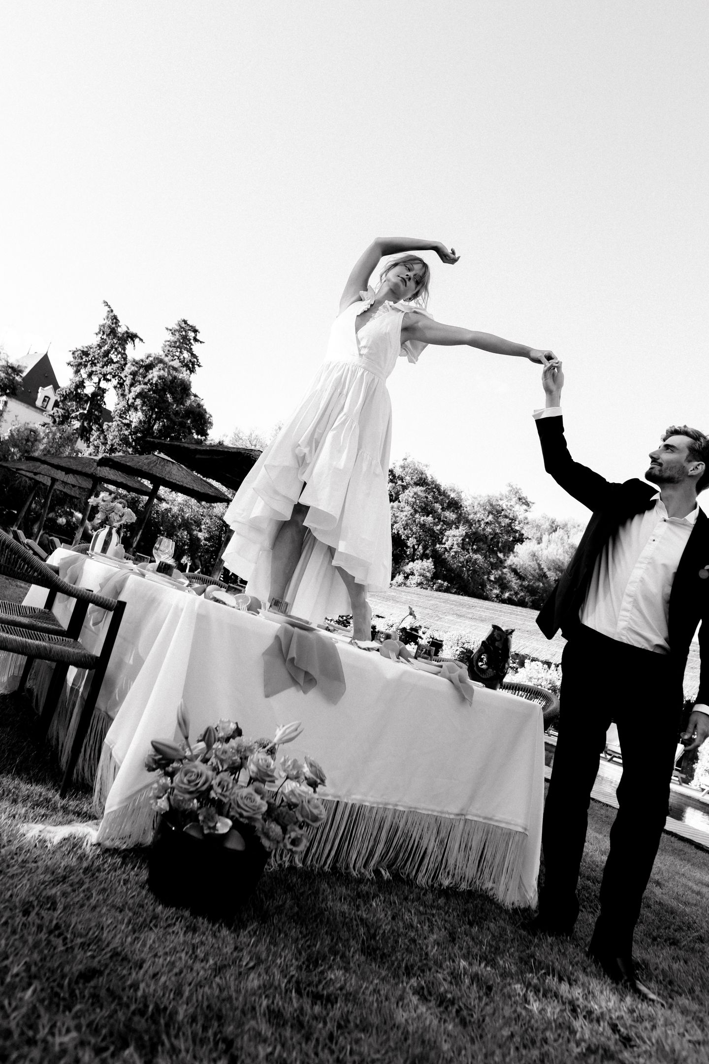 A couple stands outdoors at sunset.