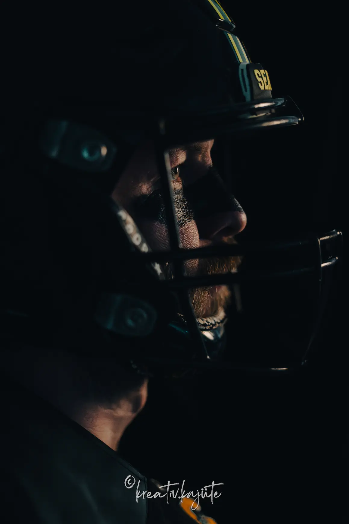 Nahaufnahme eines American Football Spielers mit Helm und konzentriertem Blick