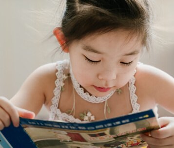 criança lendo livro