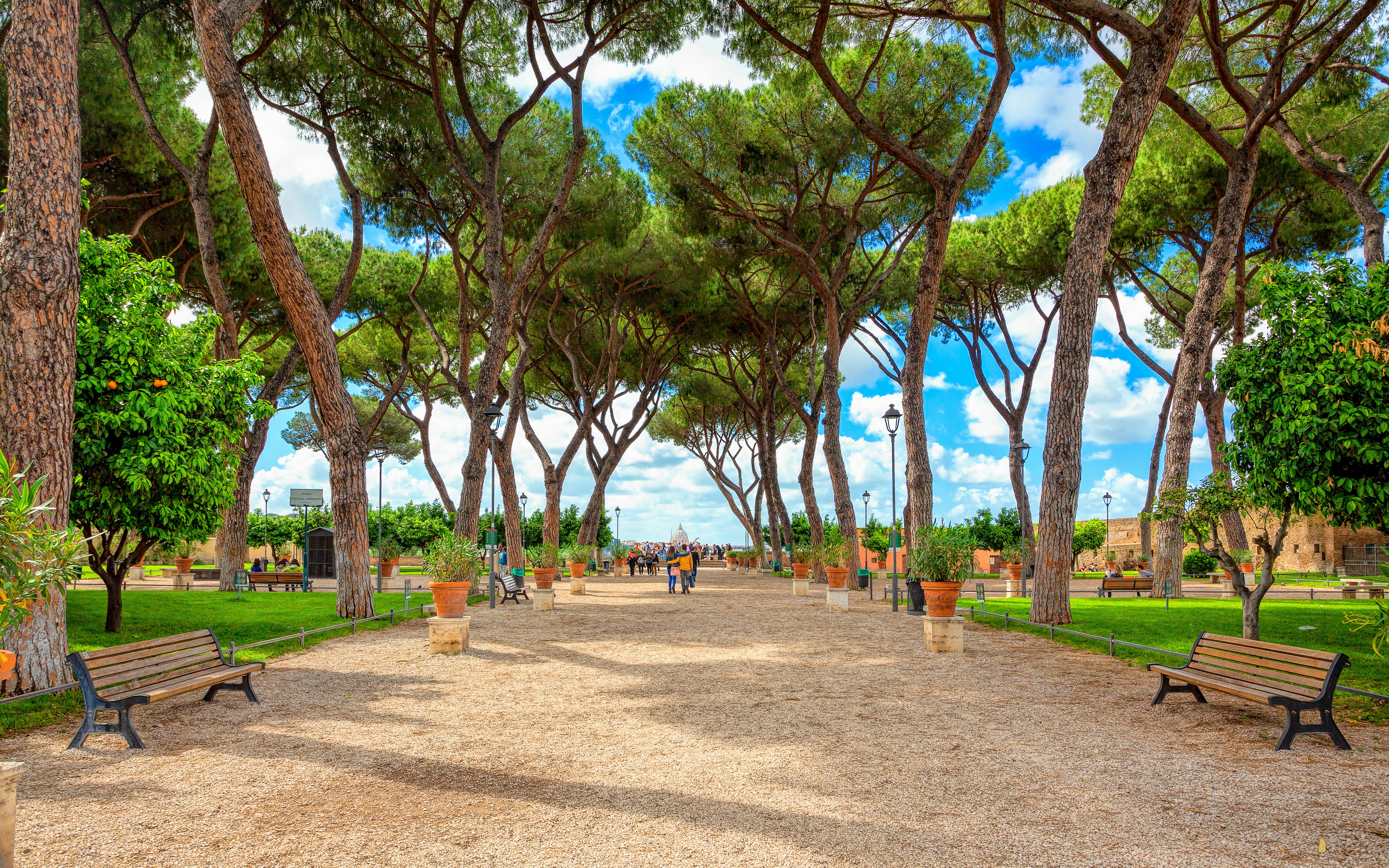 停放在罗马特拉斯提弗列区鹅卵石街道上的 Vespa 摩托车