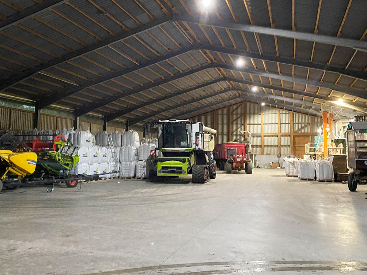 Warehouse containing pallets of bulk bags and harvesting equipment