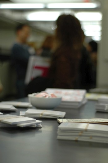 A photo of some cards held together by rubber bands and a white salad bowl on a table.