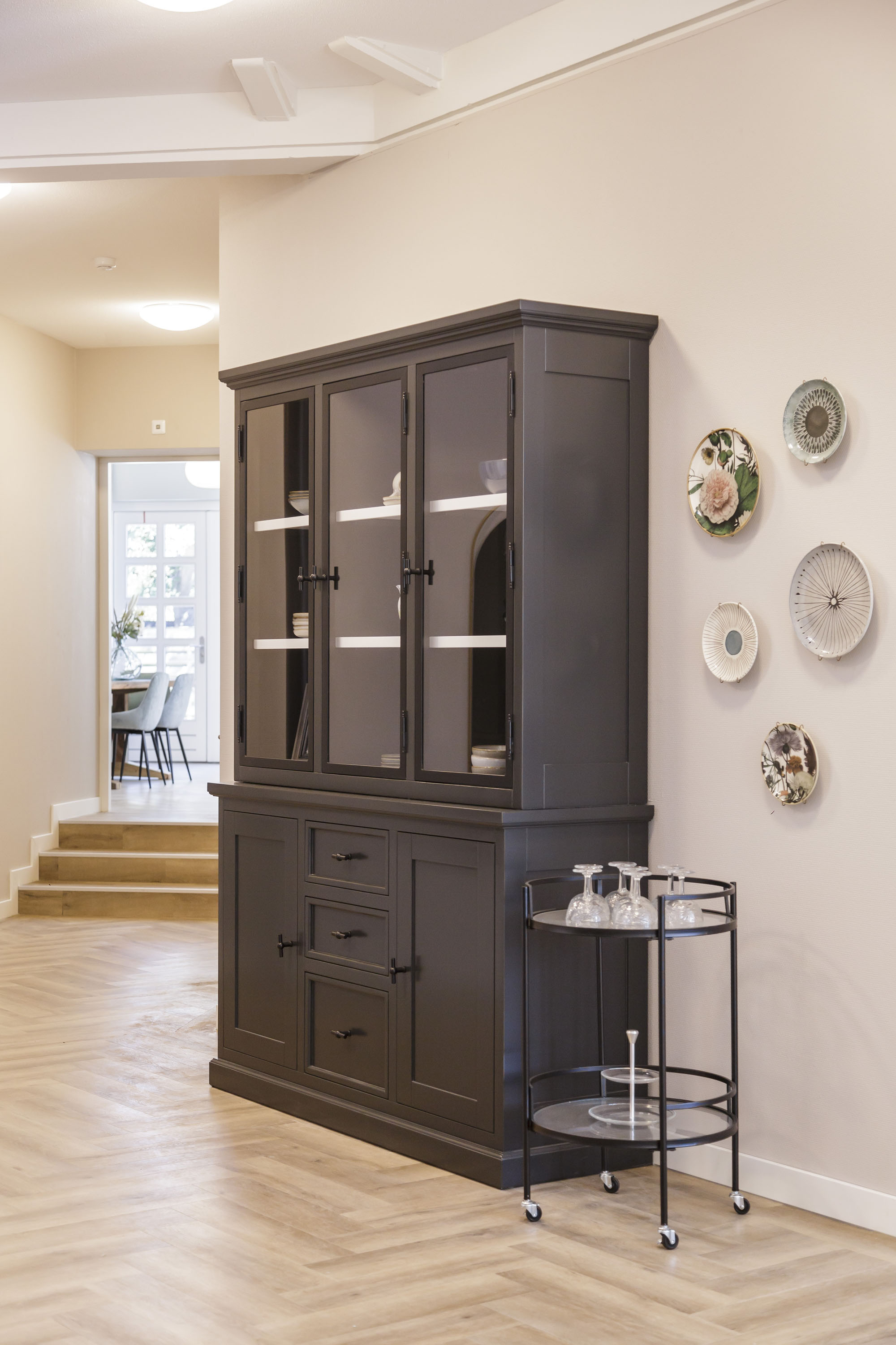 zwarte servieskast met borden aan de muur styling