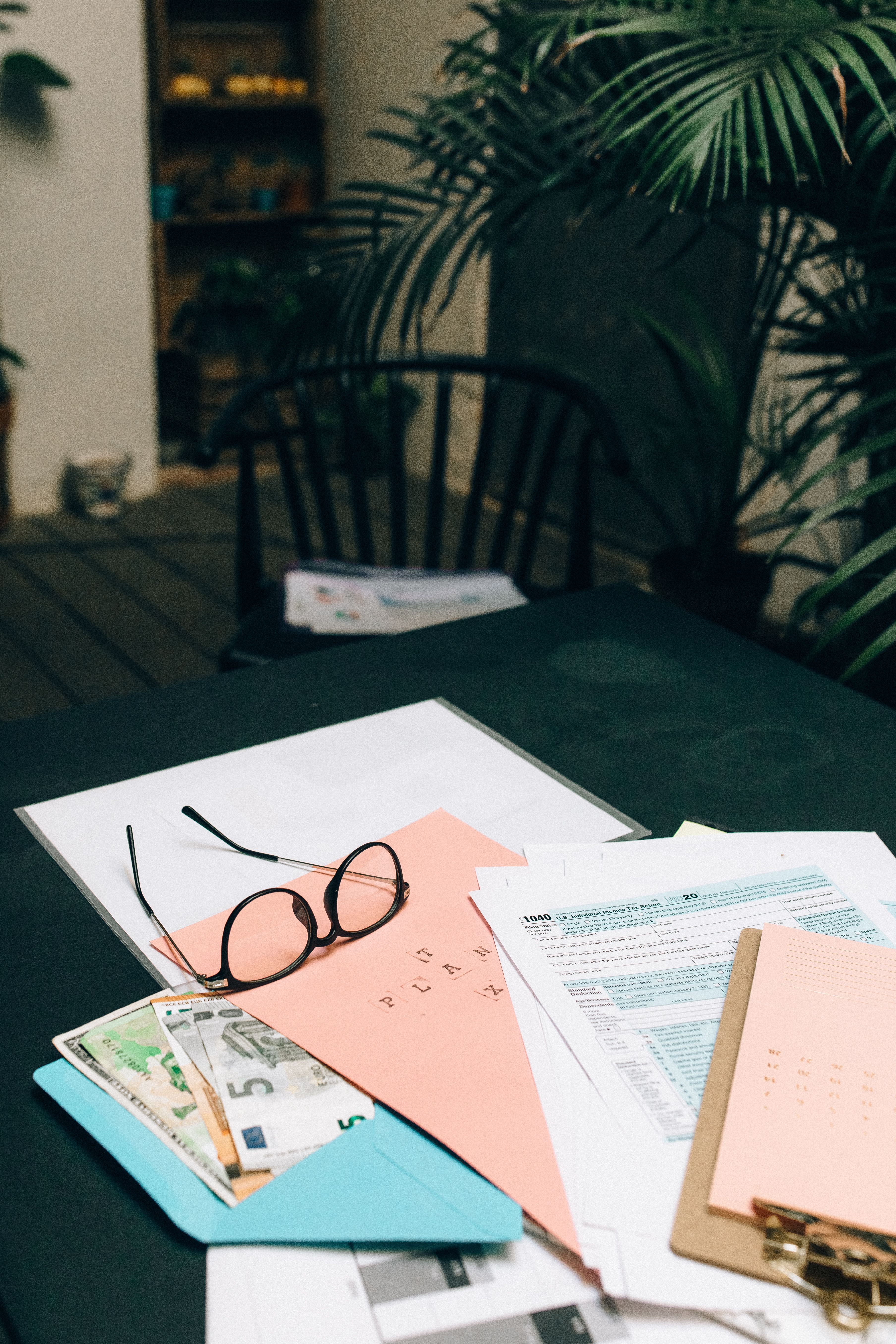 a pair of glasses sitting on top of a pile of paper