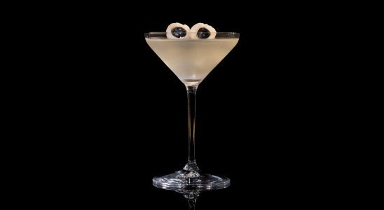 A closeup of a Sweet, Autumn Saketini drink against a dark background.