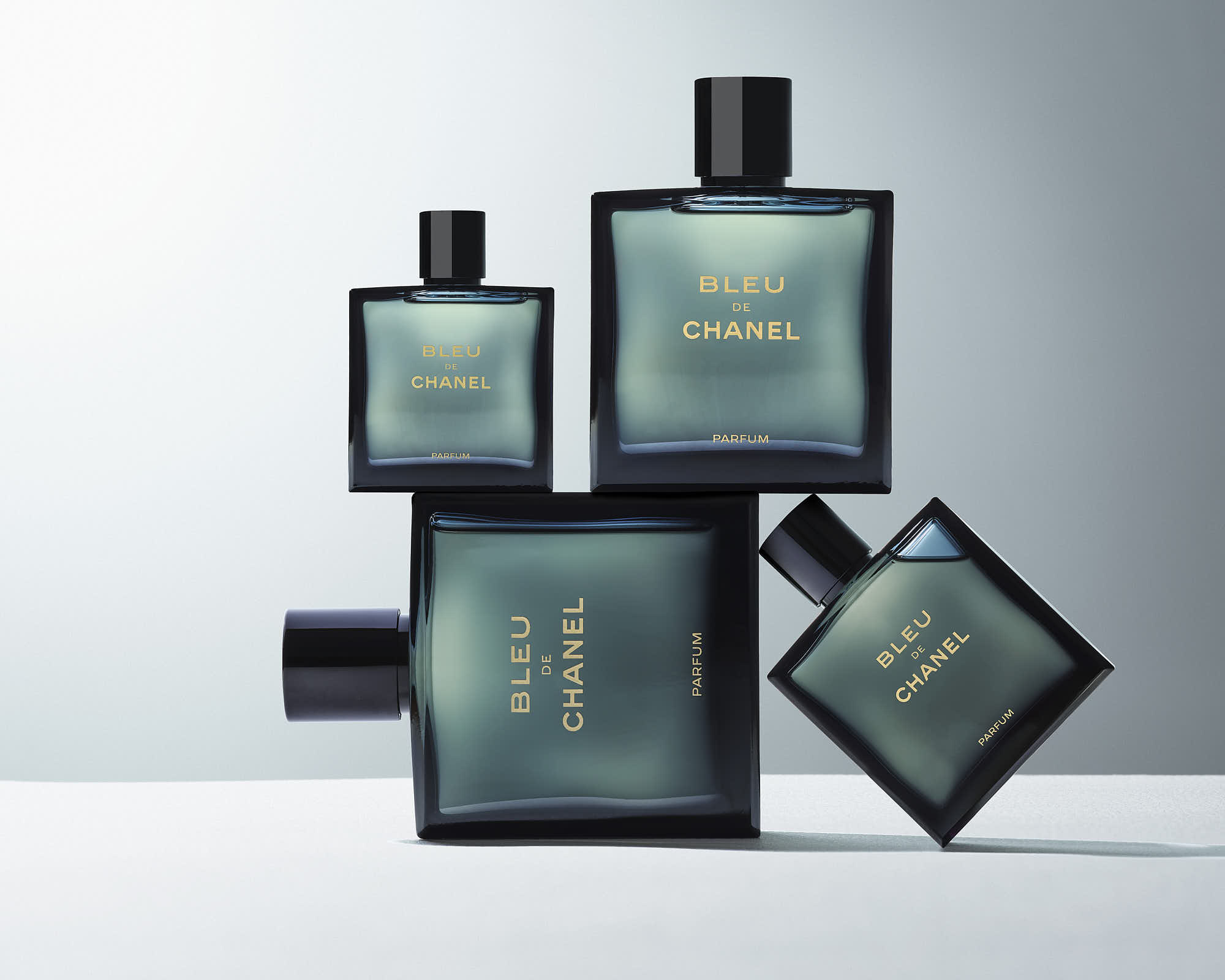 Bleu de Chanel parfum bottles arranged artistically against a light background.