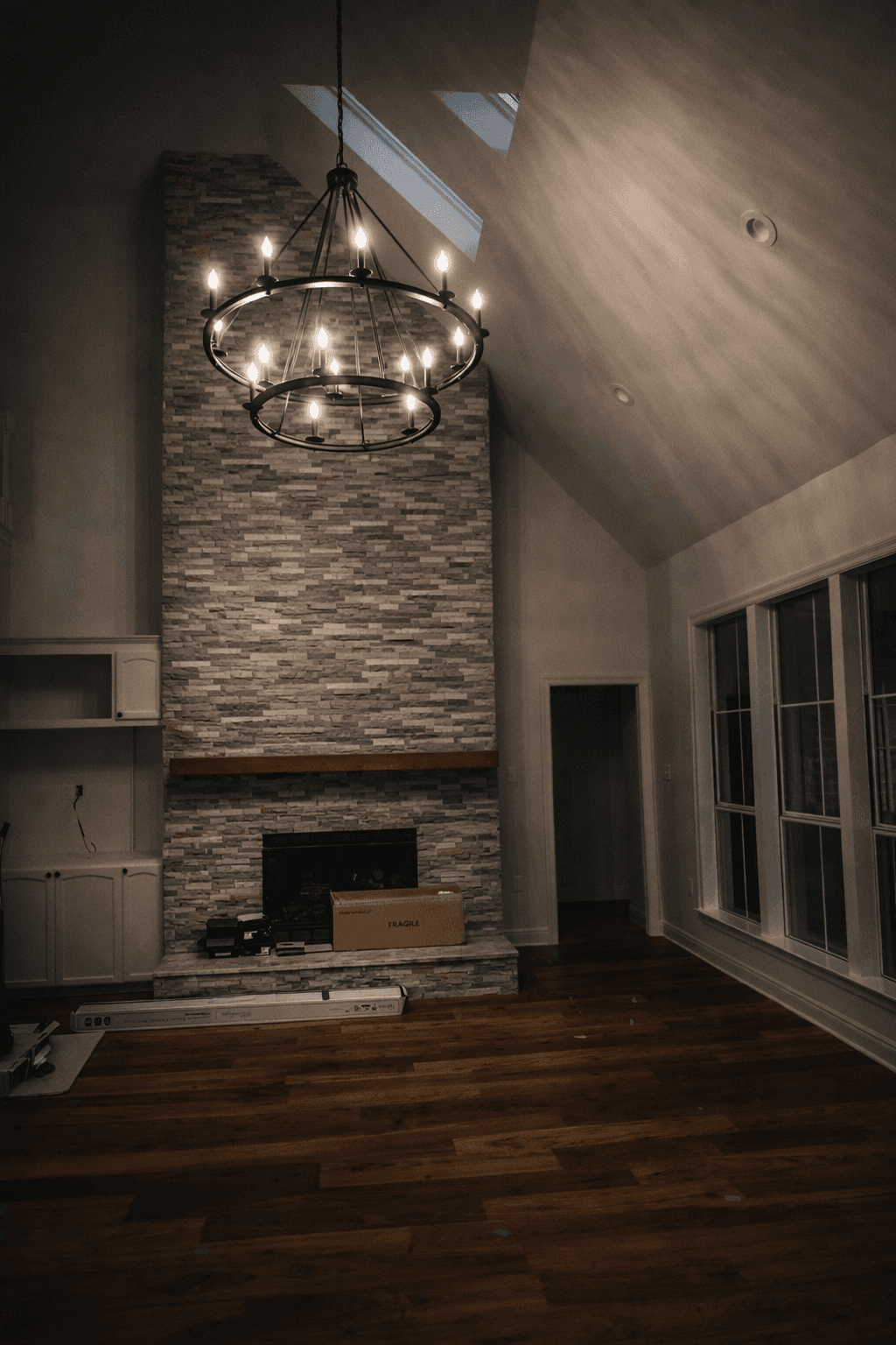 Modern bathroom featuring a walk-in shower, wooden vanity, round mirror, and elegant marble tiles.