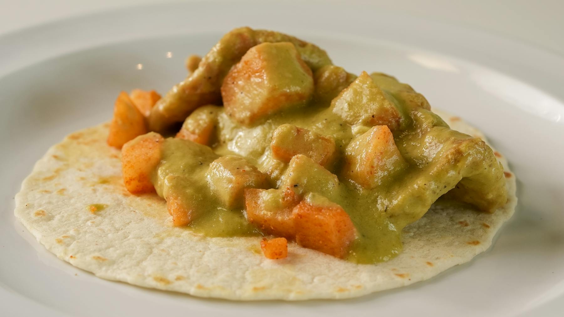 Indulge in tender pork skin simmered in a robust green sauce with hearty potatoes