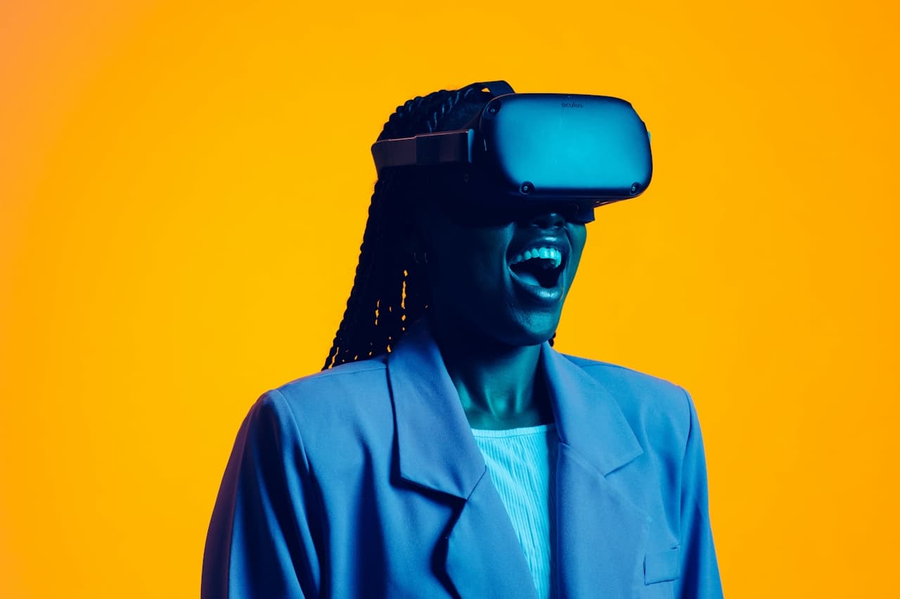 Woman wearing AR goggles and smiling against a yellow background. 