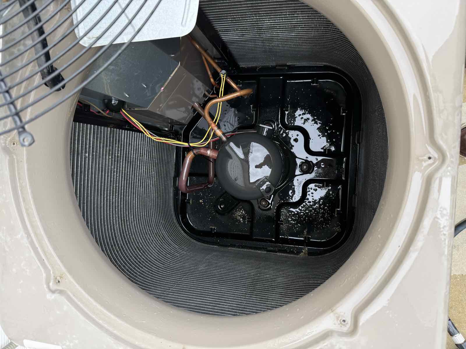 The interior floor of an air conditioning condenser cabinet after cleaning, with the weep holes clear.