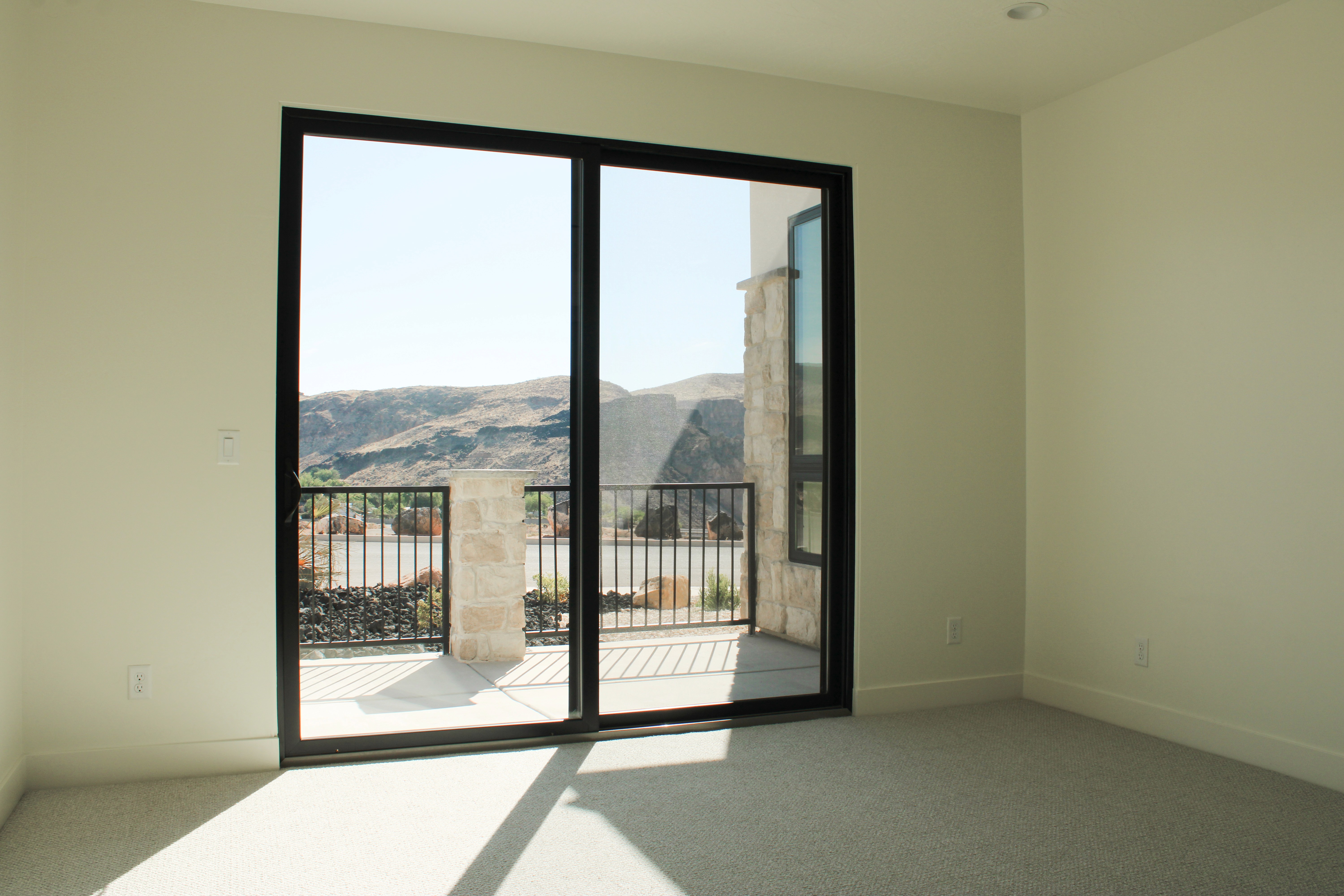 Unfurnished primary bedroom at The Overlook at Falcon Ridge in Hurricane, Utah, featuring a sliding glass door with direct outdoor access.