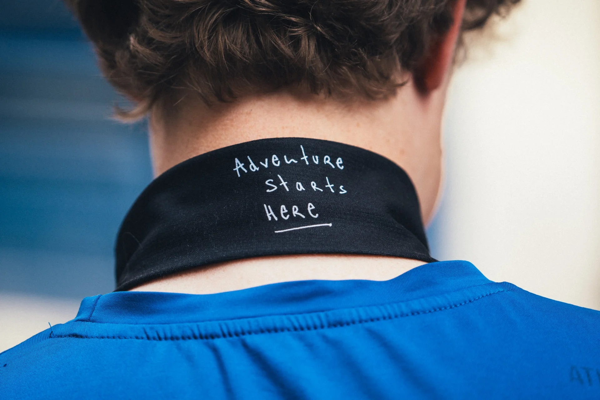 Détail du col d’un coureur avec l’inscription « Adventure starts here » sur le textile Suunto.