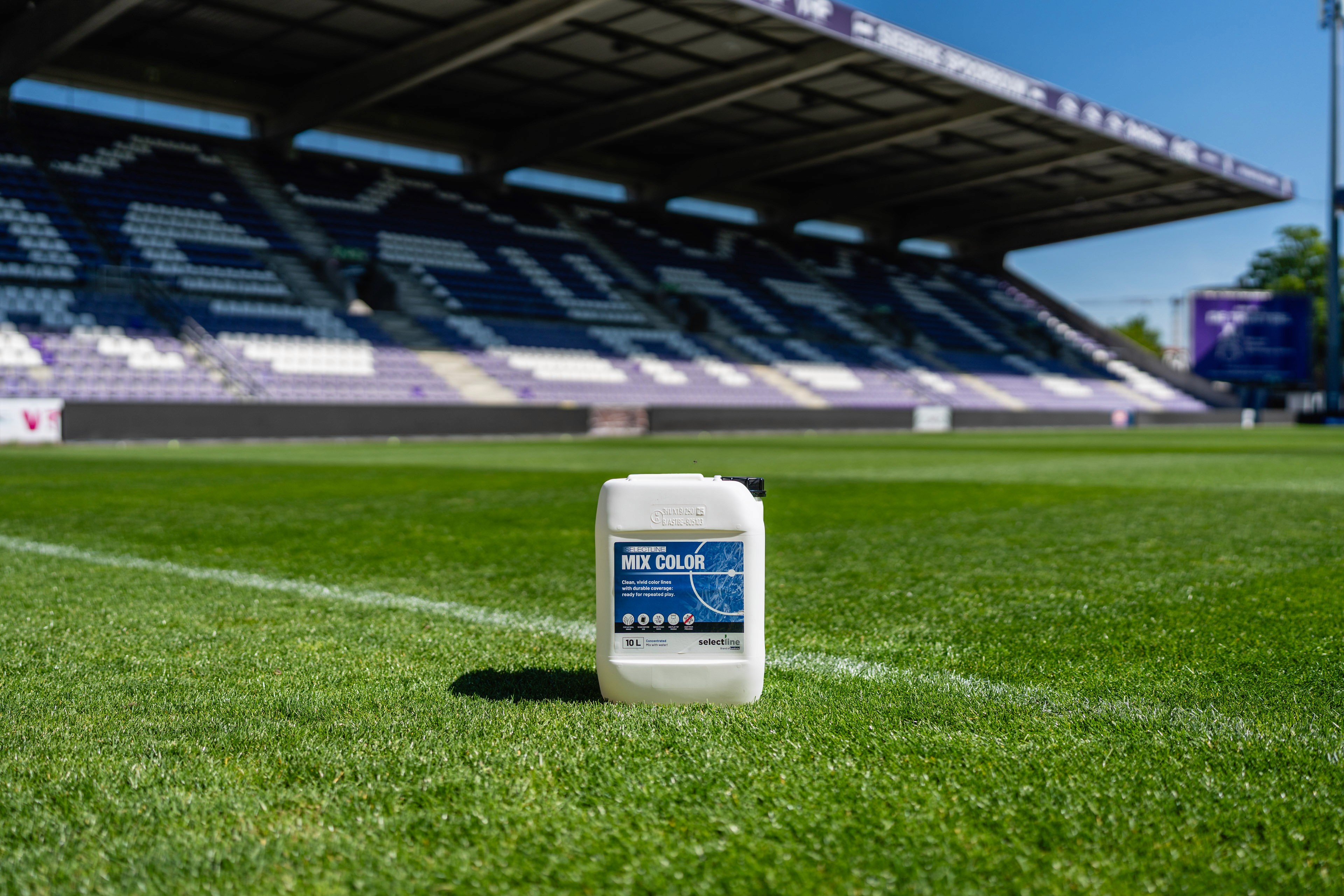 Selectline PRO COLOR-jerrycan op het gras van een voetbalstadion, klaar voor gebruik.