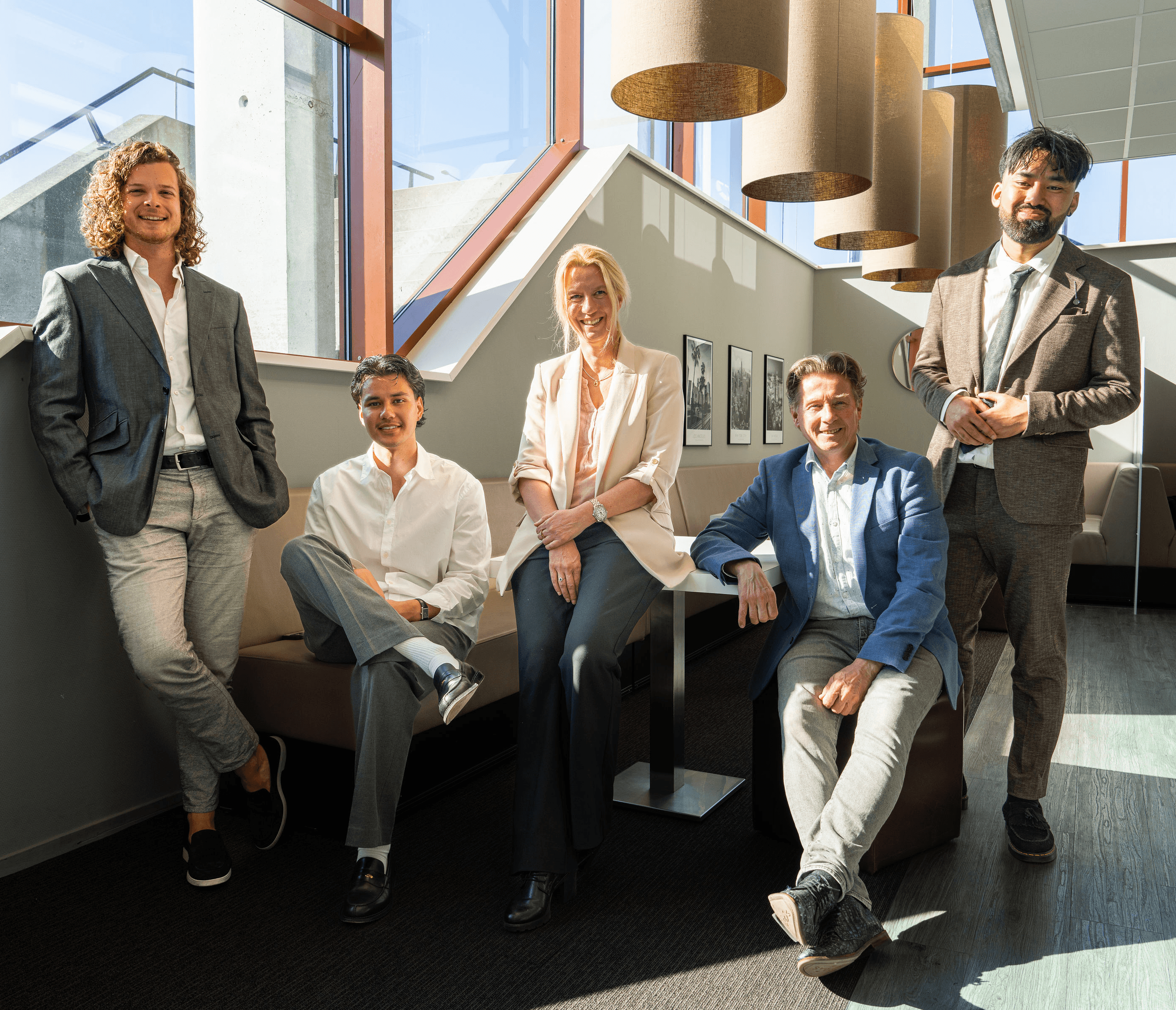 The SETTL team smiling and sitting together in their Amsterdam office