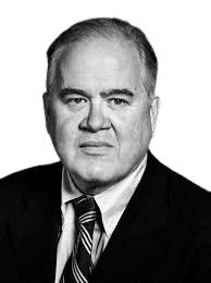 A black-and-white portrait of an older man with short, neatly combed gray hair, wearing a suit and striped tie. His serious expression and formal attire suggest a professional or authoritative role, giving the image a classic, dignified tone.