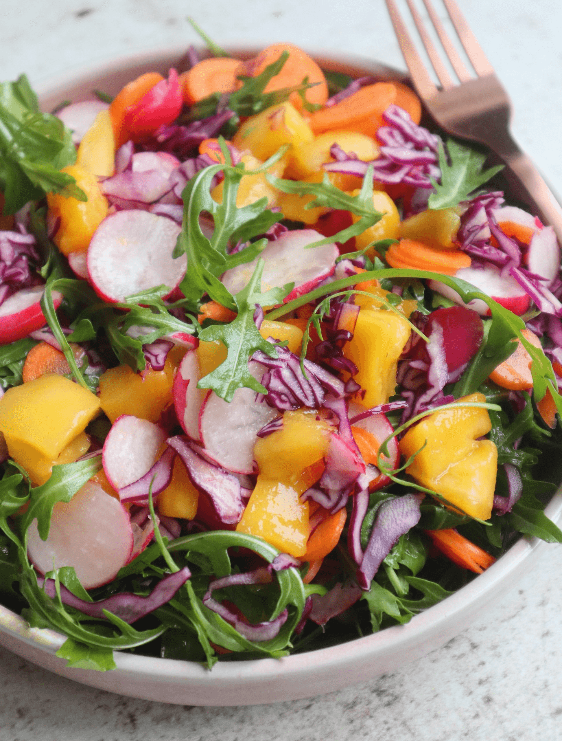 sliced broccoli and cucumber on plate with gray stainless steel fork near green bell pepper, snowpea, and avocado fruit