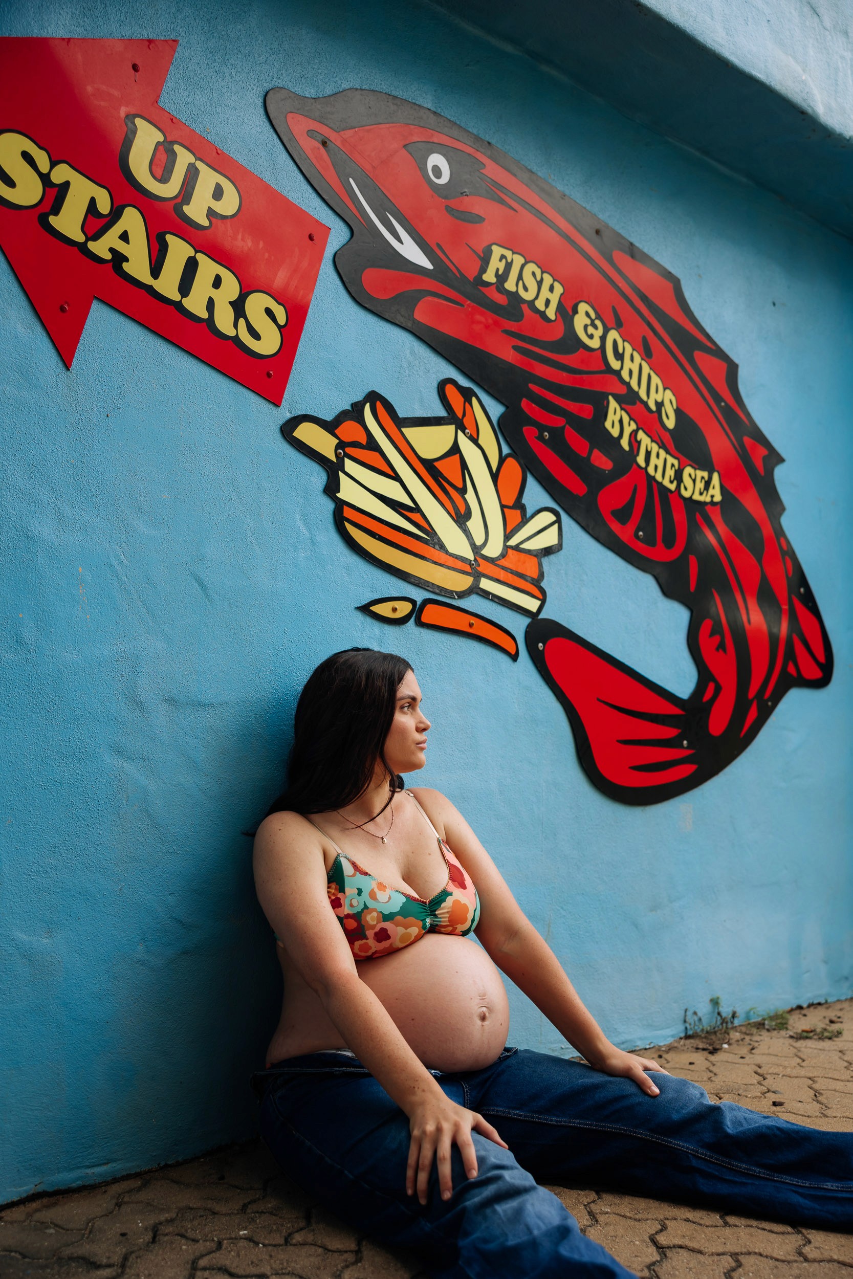 Editorial maternity photoshoot at Mackay Surf Life Saving Club featuring pregnant woman in modern coastal setting