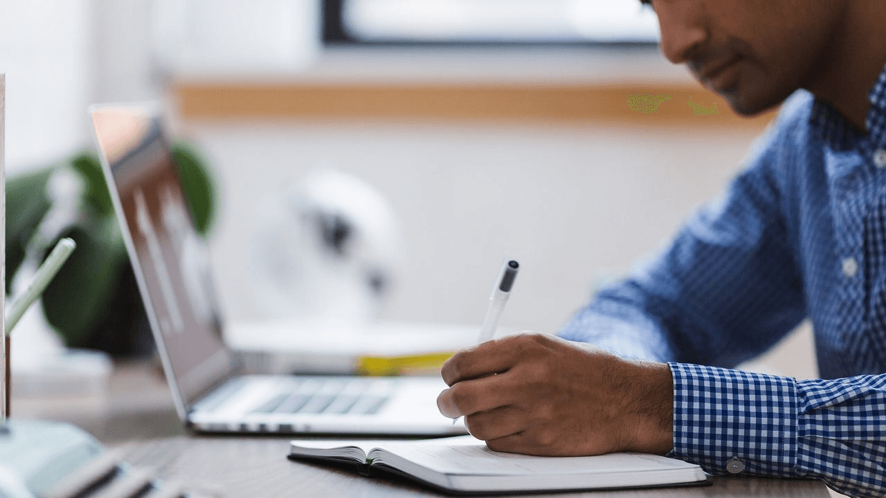 High school student writing a research paper outline with organized notes and a structured template on a desk