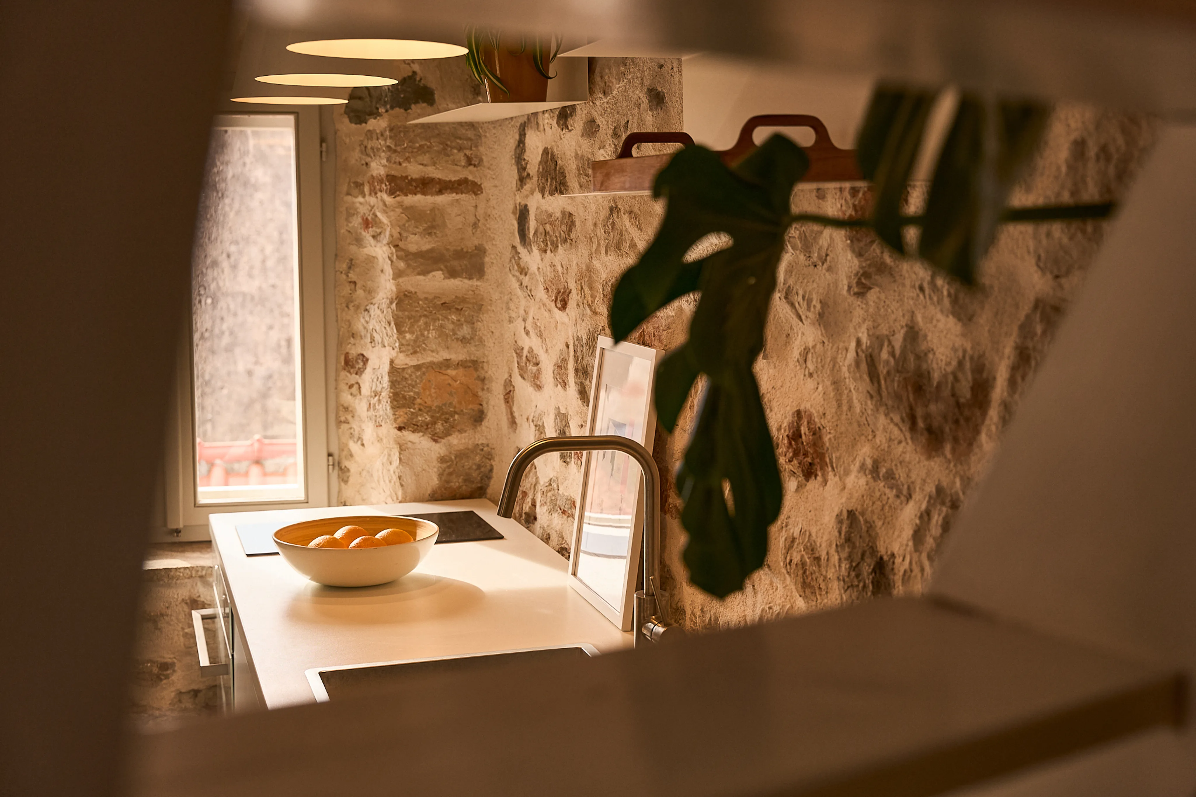 Atmospheric kitchen with stone wall and monstera leaf shadow, Hidden House boutique townhouse, Stari Grad Hvar